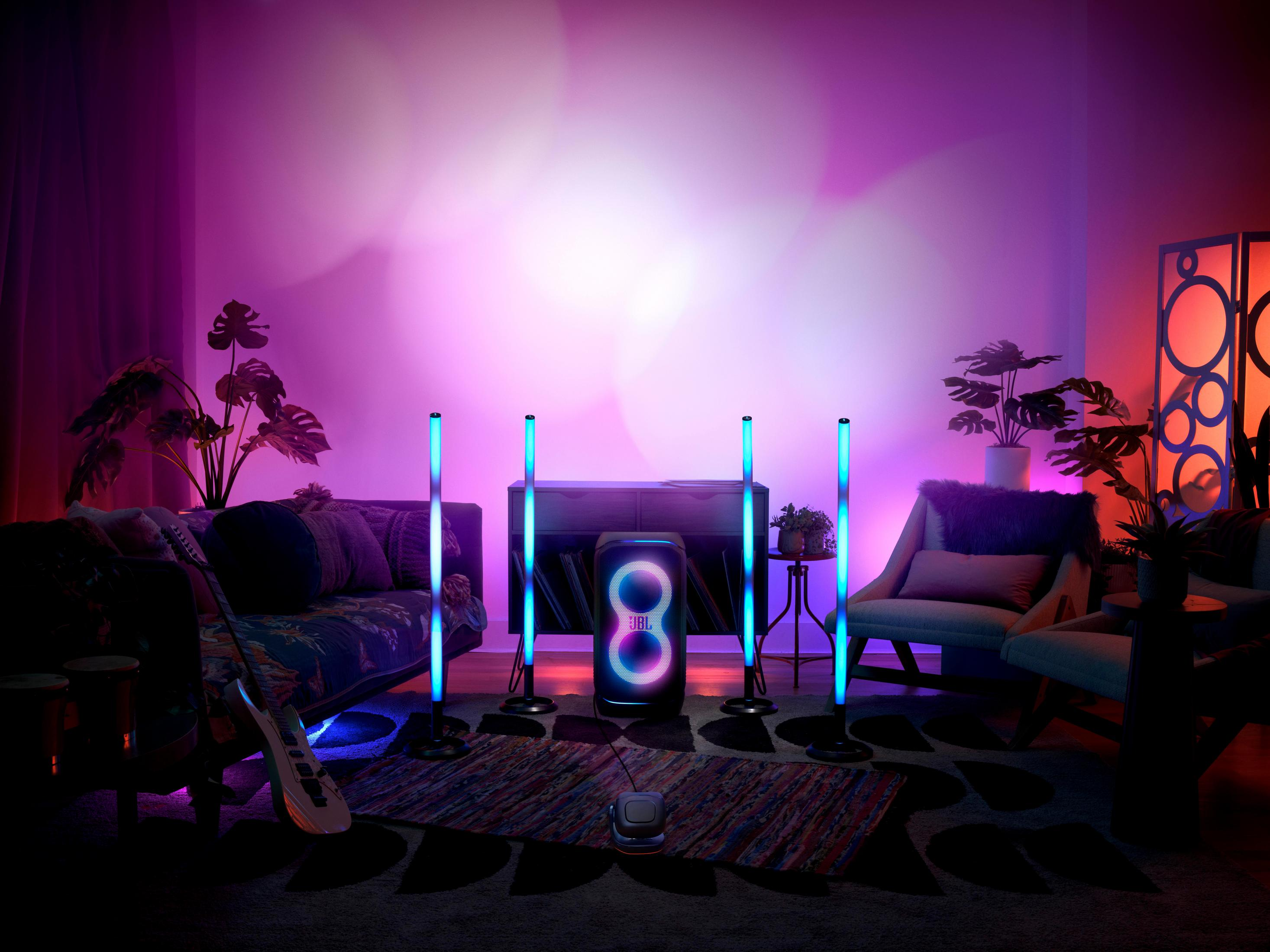 Stanza con altoparlanti e luci JBL. Altoparlanti e luci sono su supporti. Luce ambientale viola e blu.