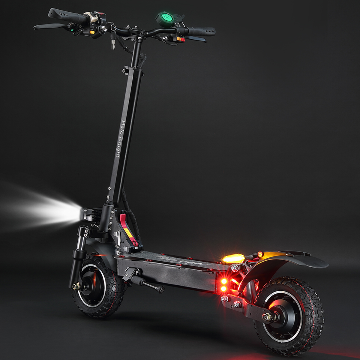 Czarna hulajnoga ze światłami włączonymi w ciemności, czerwone światła tylne.