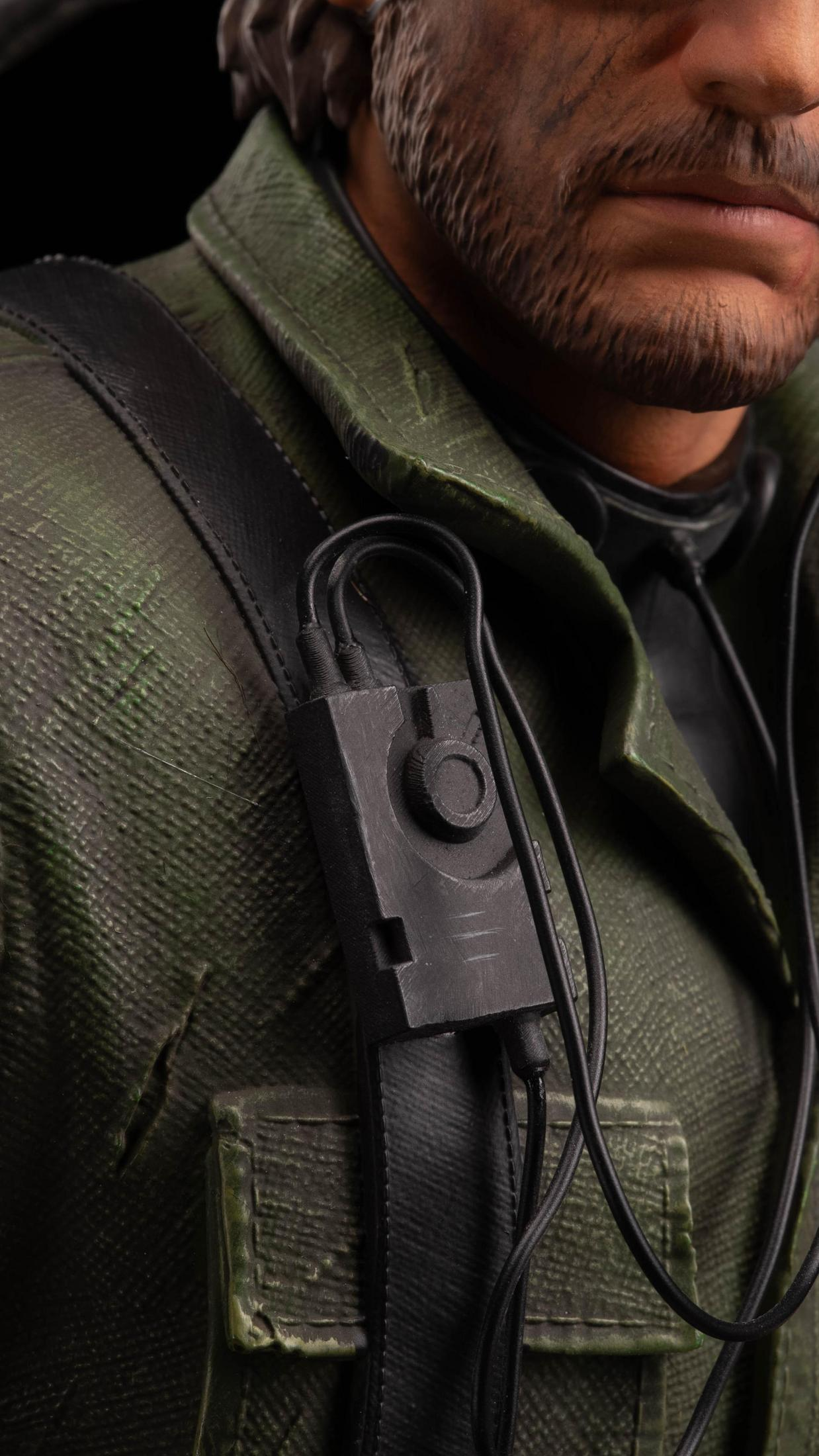 Zbliżenie twarzy mężczyzny i części jego munduru wojskowego z urządzeniem komunikacyjnym.