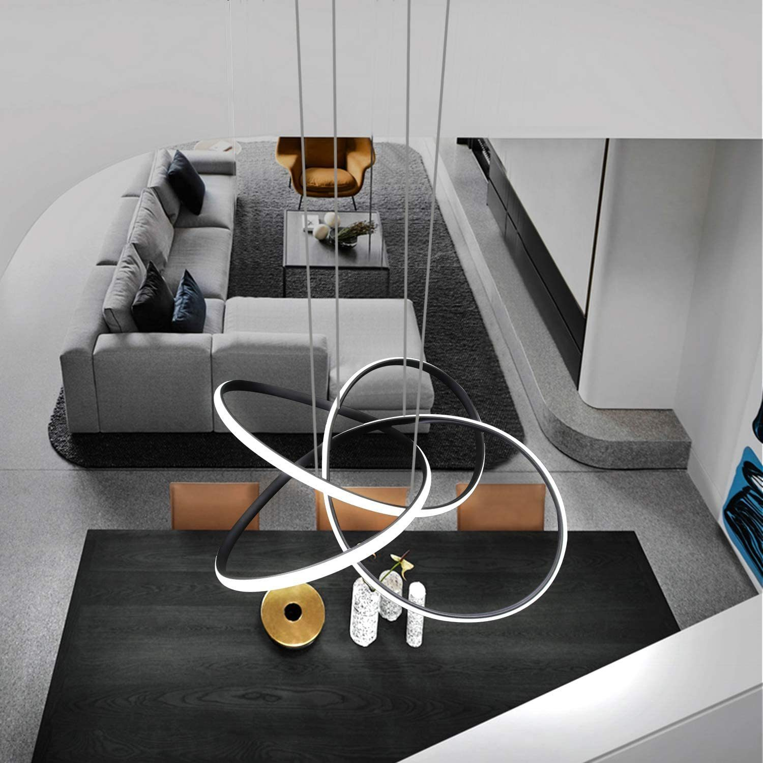 Draufsicht auf ein modernes Wohnzimmer mit dunklem Holztisch und Kronleuchter.