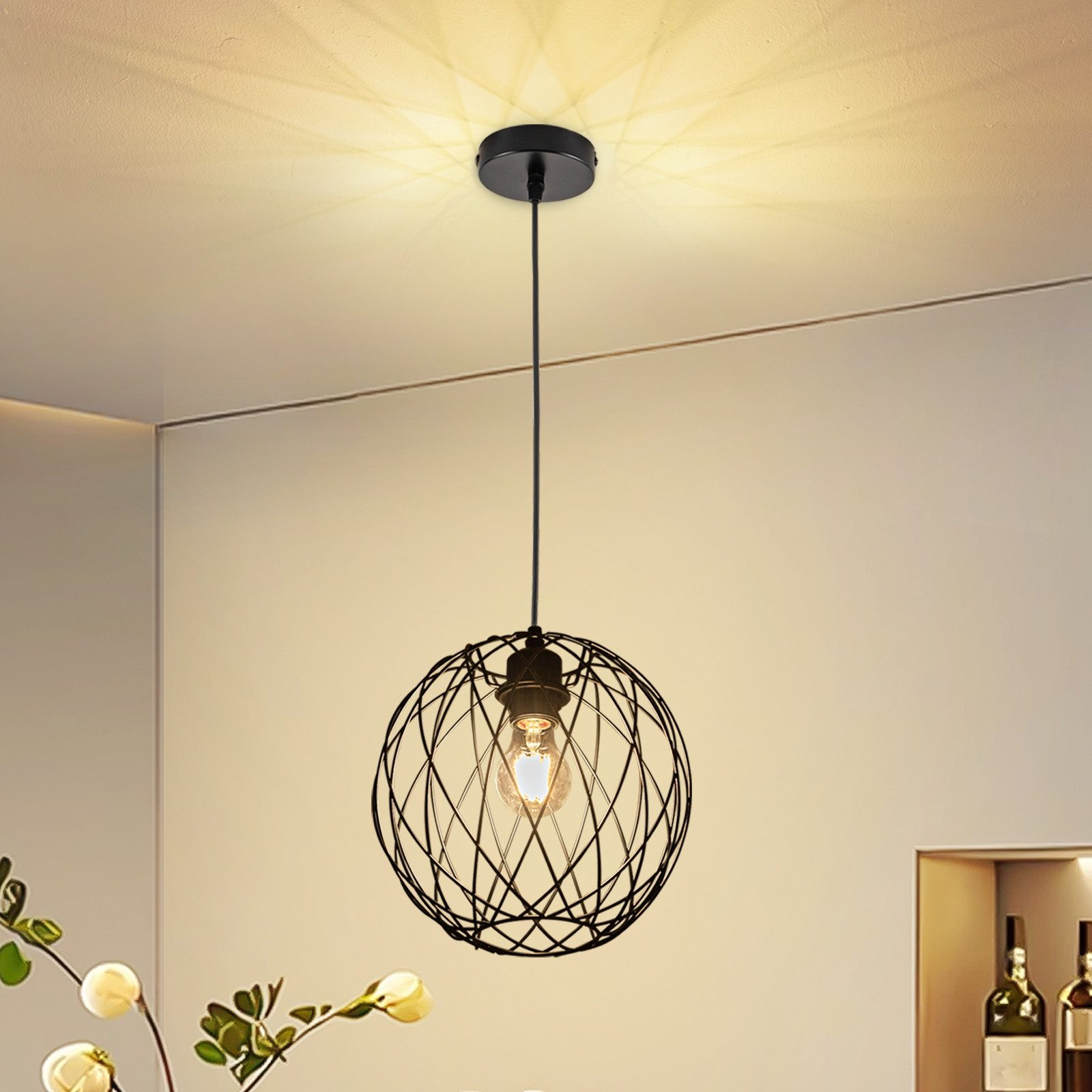Eine schwarze Drahtgestell-Pendelleuchte mit Glühbirne, die von der Decke hängt. Das Licht ist an.