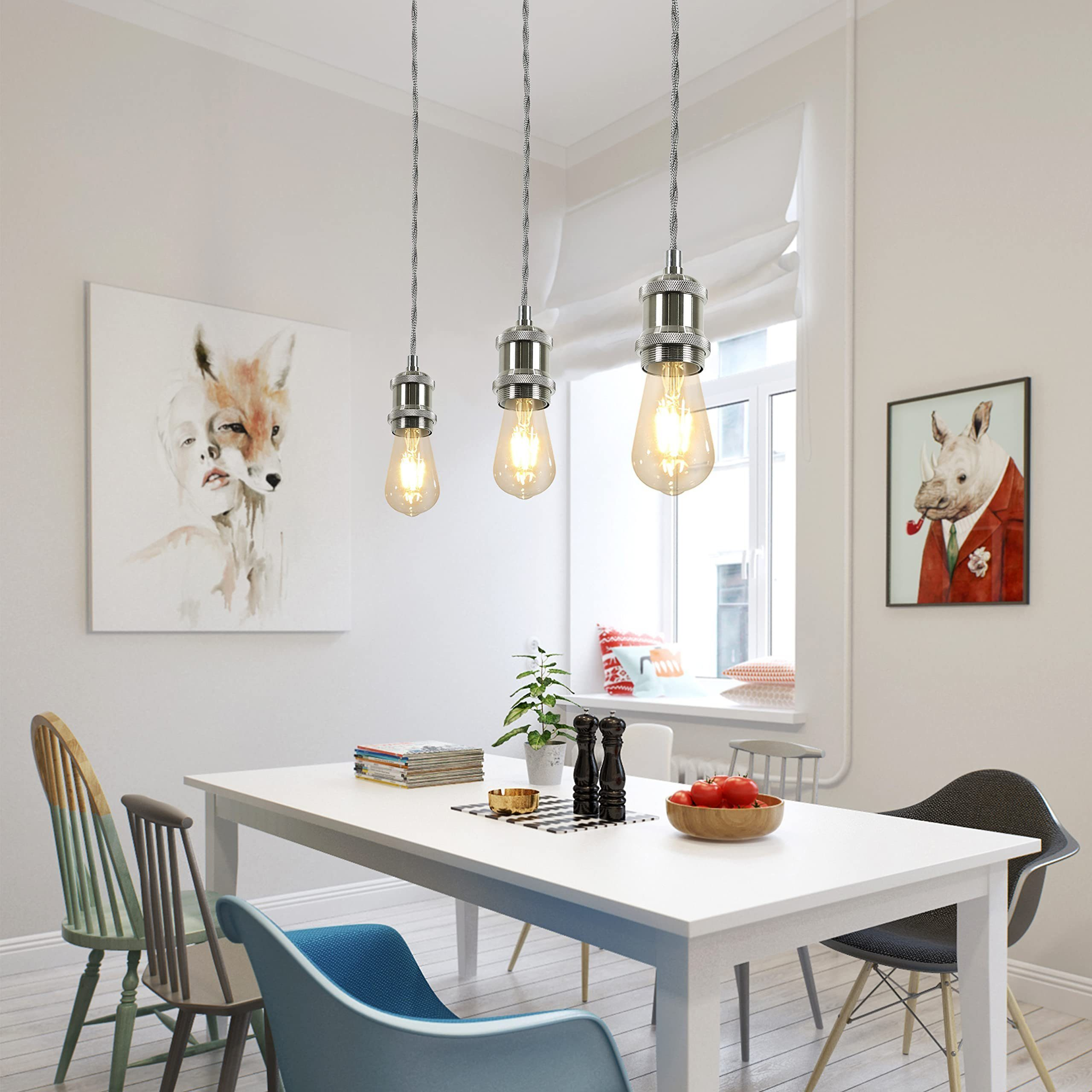 Sala da pranzo con tavolo bianco, tre lampadine a sospensione, arte e sedie.