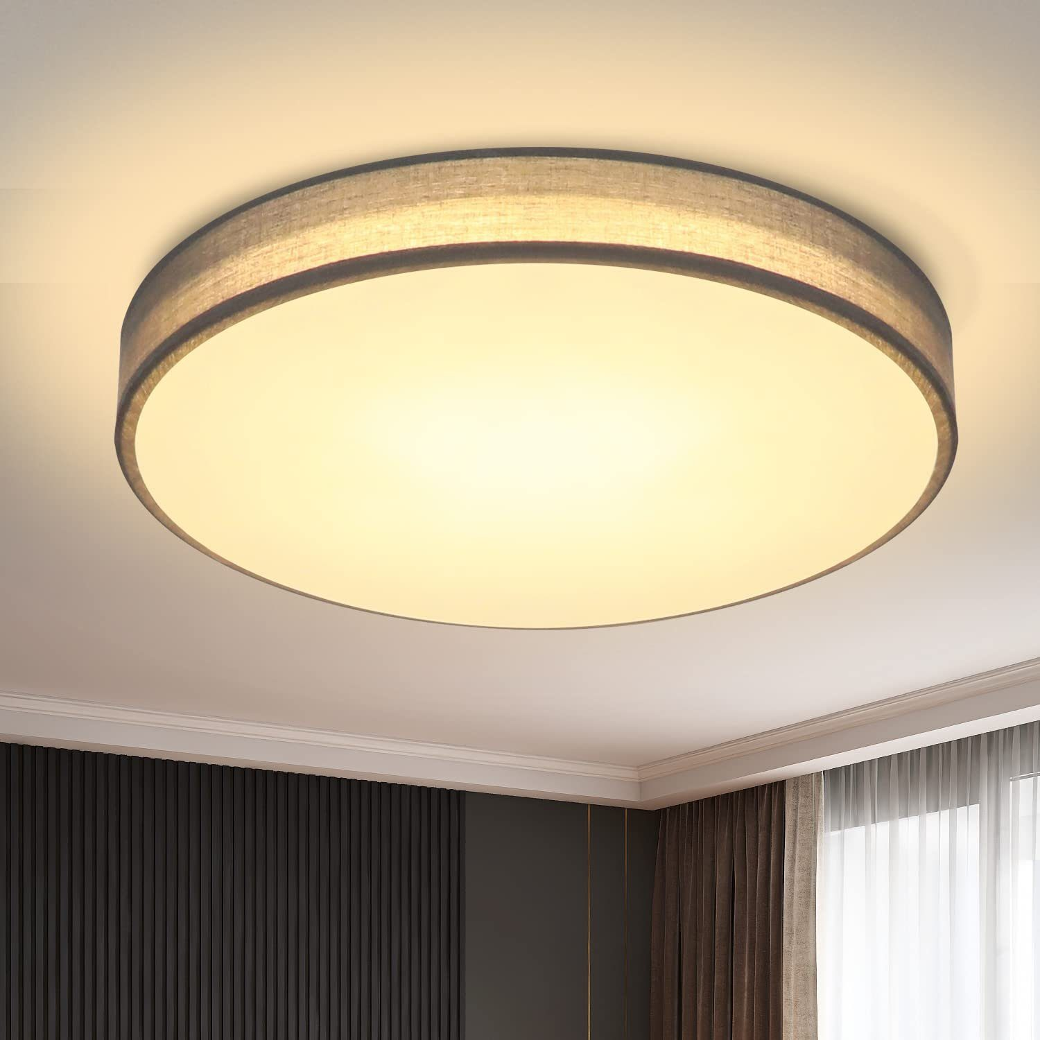 Eine runde Deckenleuchte mit grauem Stoffrand. Das Licht ist an, und der Hintergrund ist eine weiße Decke.