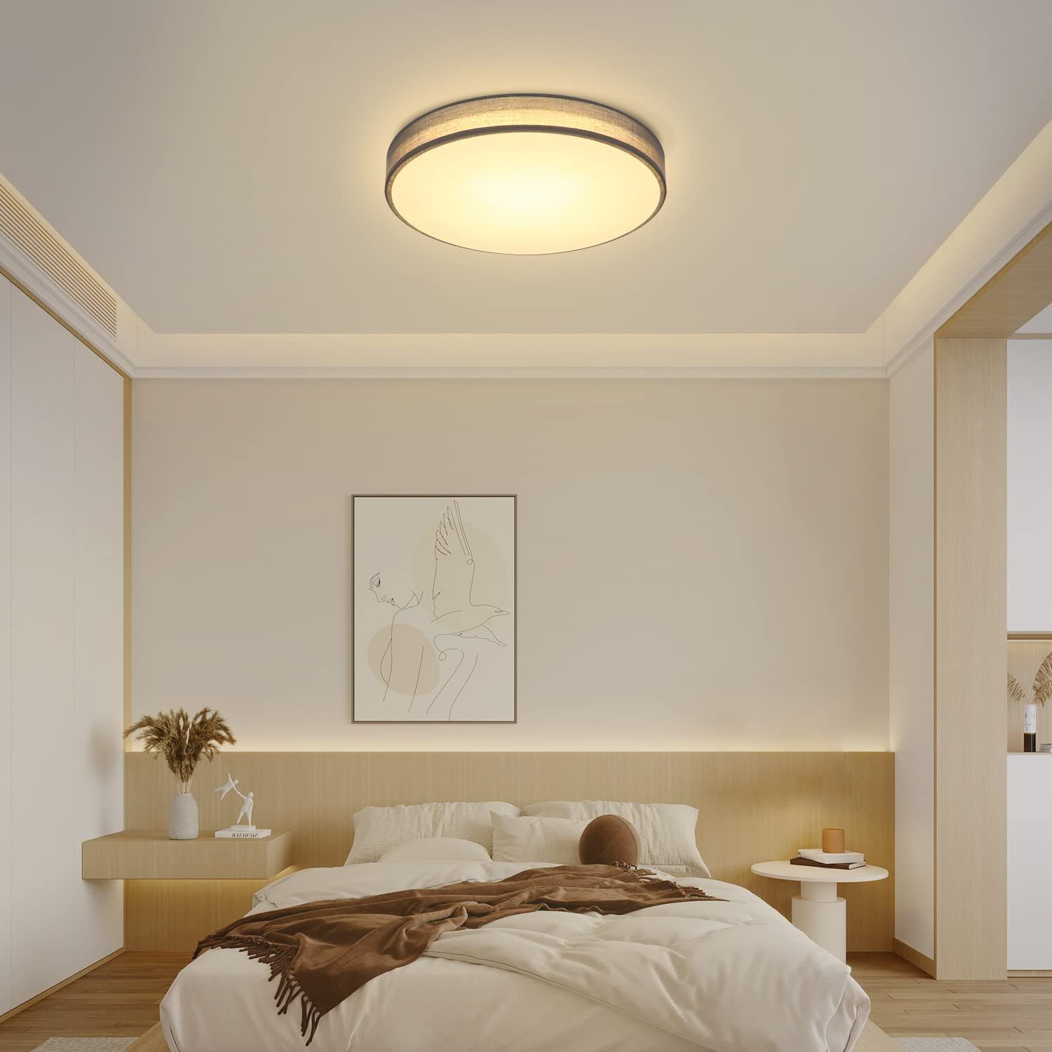 Schlafzimmer mit Deckenleuchte. Runde Leuchte. Bett, Bild und Nachttisch sind sichtbar.