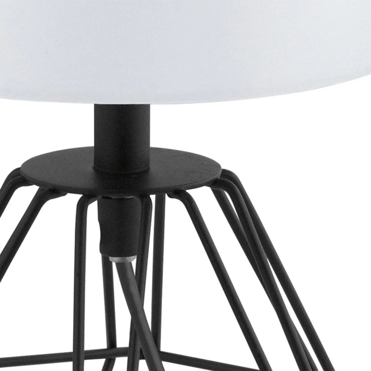 Primo piano di una base di lampada in metallo nero, con un paralume bianco sopra.