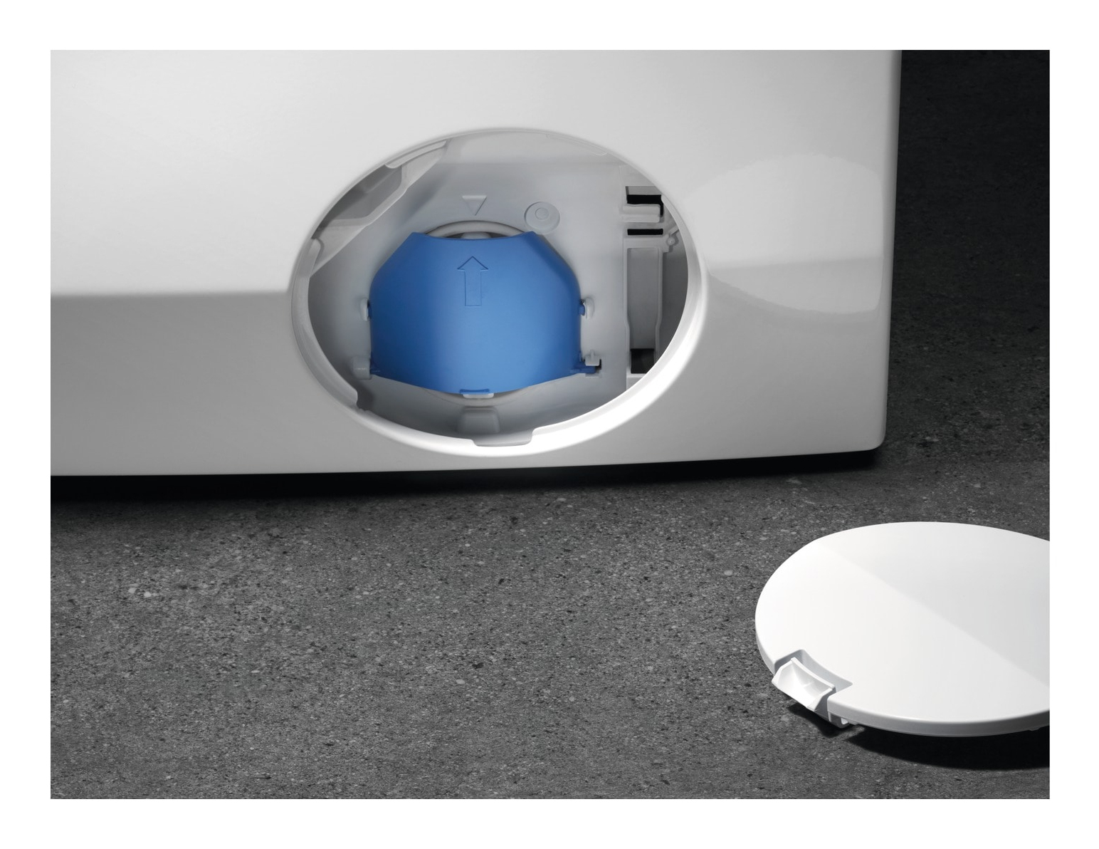 Zbliżenie na komorę filtra białej pralki z widocznym niebieskim filtrem.