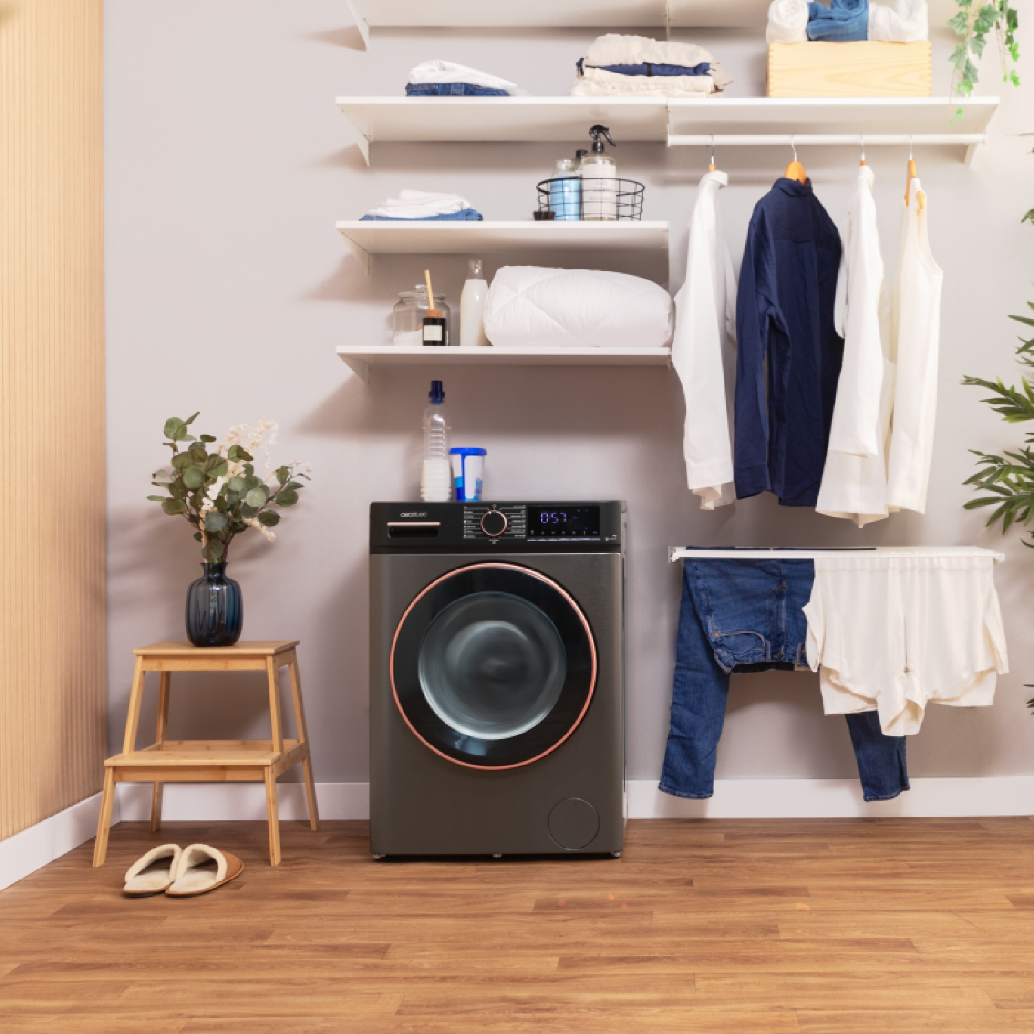 Pralnia z pralką, wiszącymi ubraniami i dekoracjami.