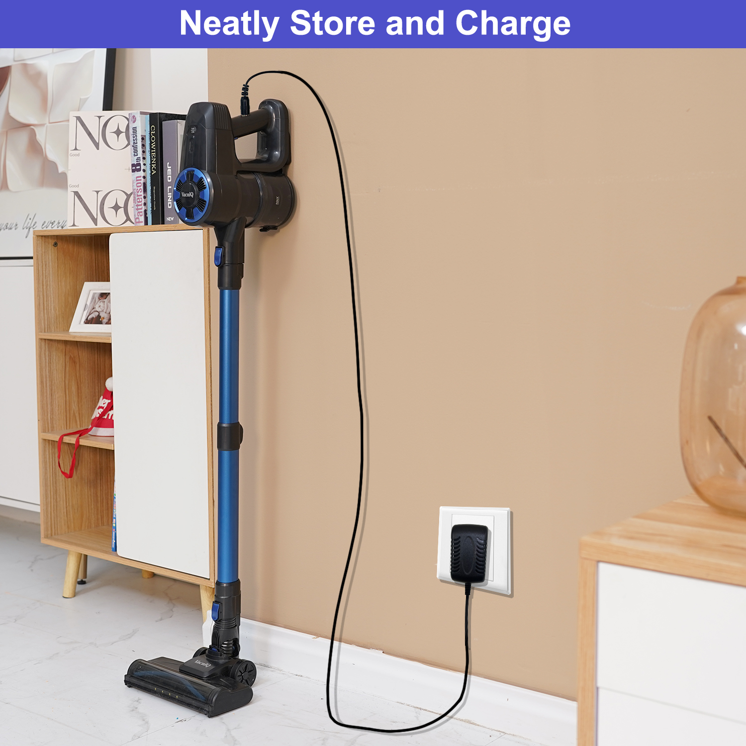 Niebiesko-czarny odkurzacz bezprzewodowy ładuje się na ścianie. Ściana jest beżowa.