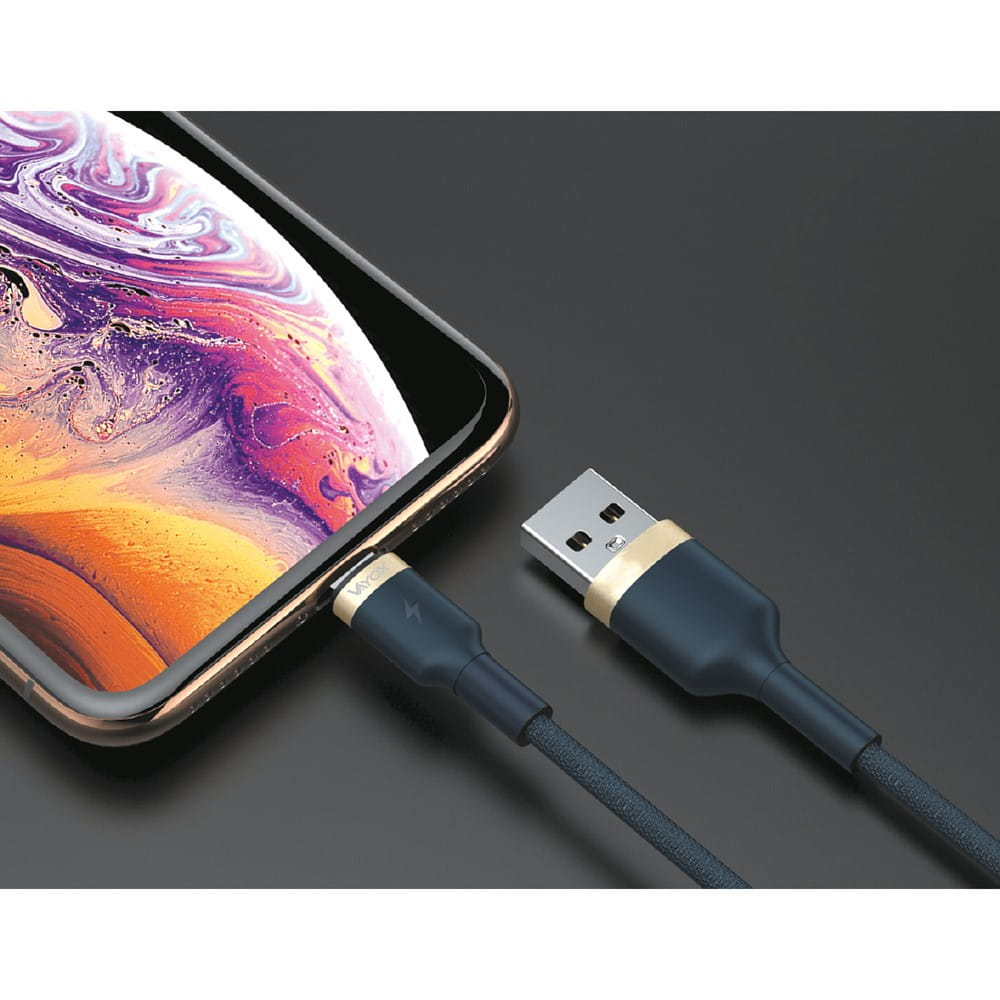 Telefon podłączony do kabla USB-C. Kabel jest ciemnoniebieski i ma złoty akcent. Ciemne tło.