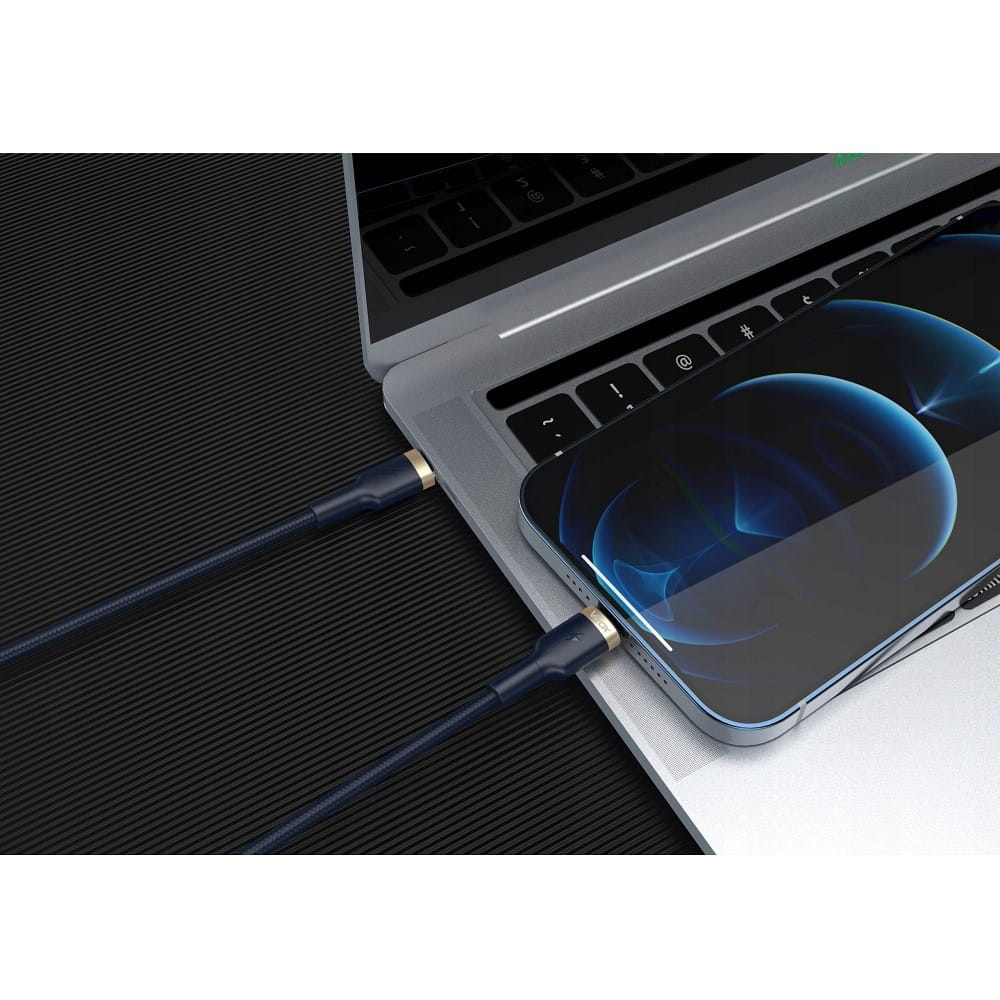 Czarno-złoty kabel ładujący podłączony do laptopa i telefonu, na czarnej powierzchni.