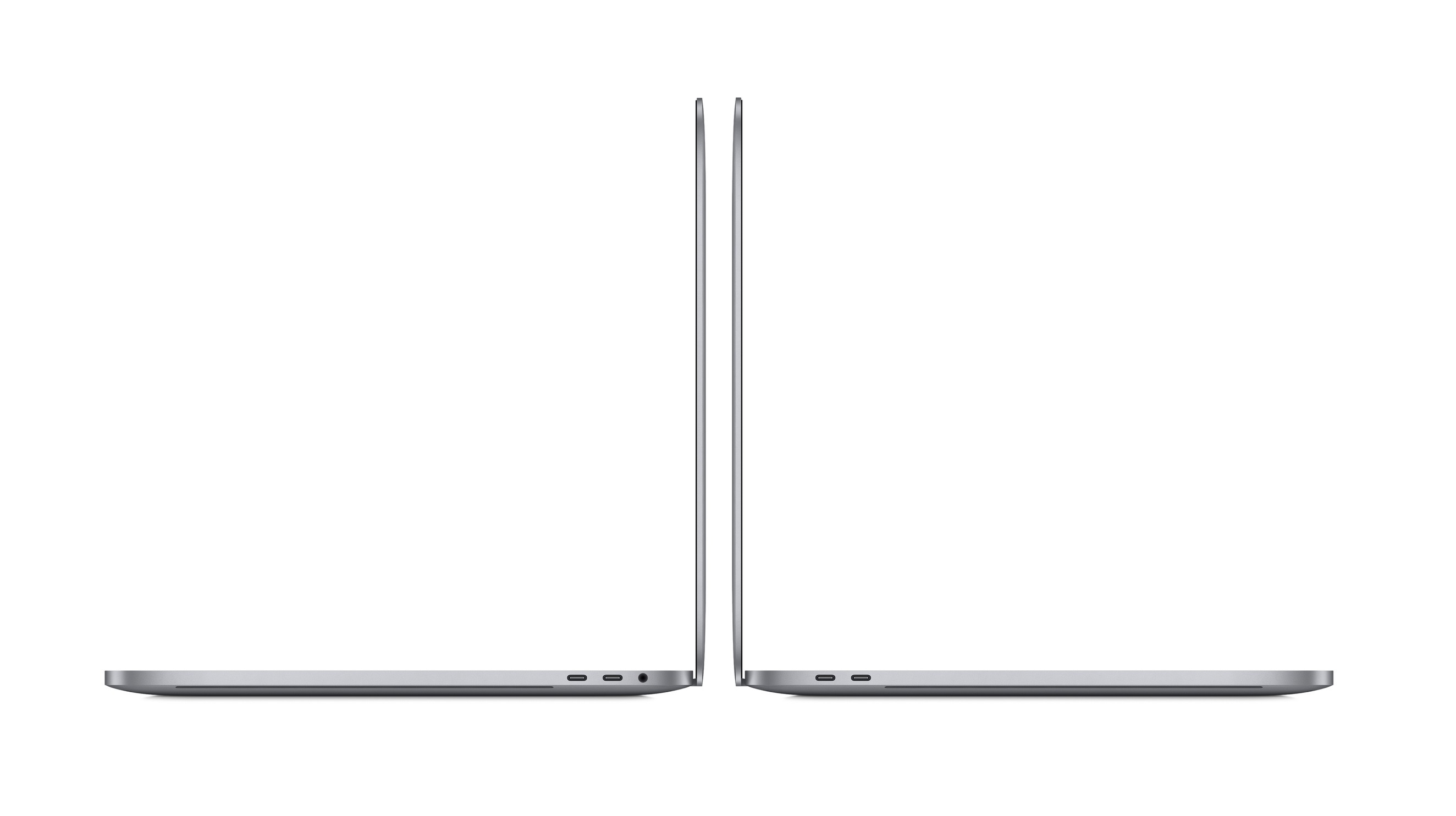 Dwa srebrne laptopy, widok z boku, zamknięte, na białym tle.