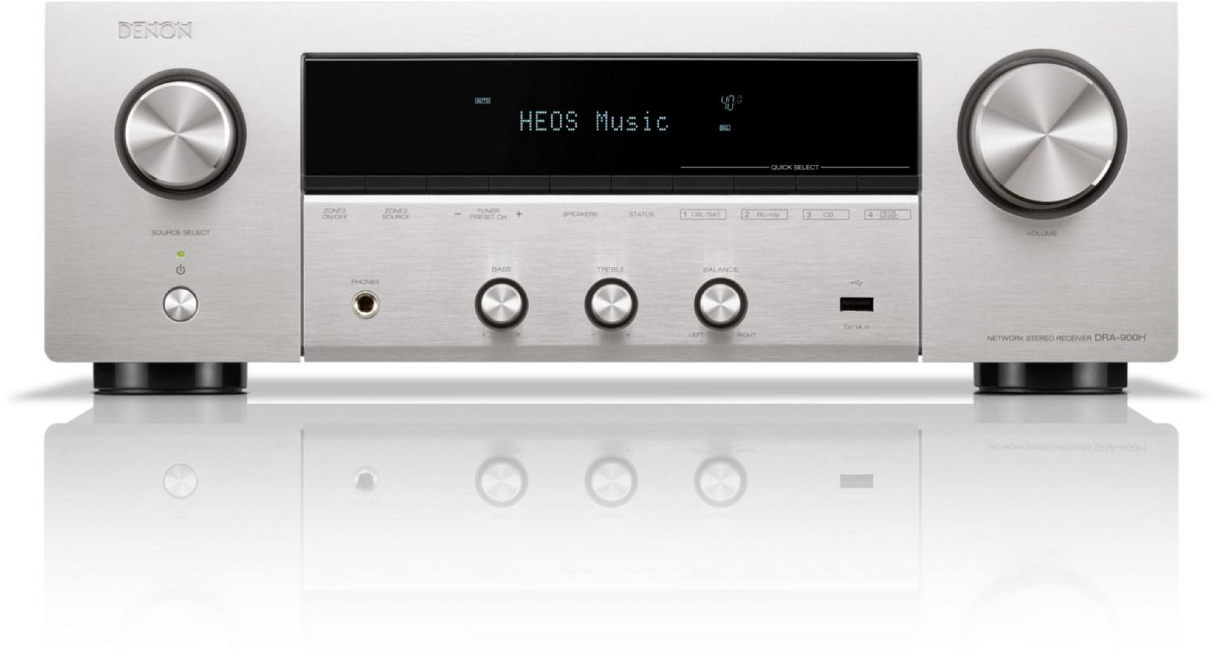 Ricevitore stereo Denon argentato. Ha un display che mostra HEOS Music. Manopole e pulsanti visibili.