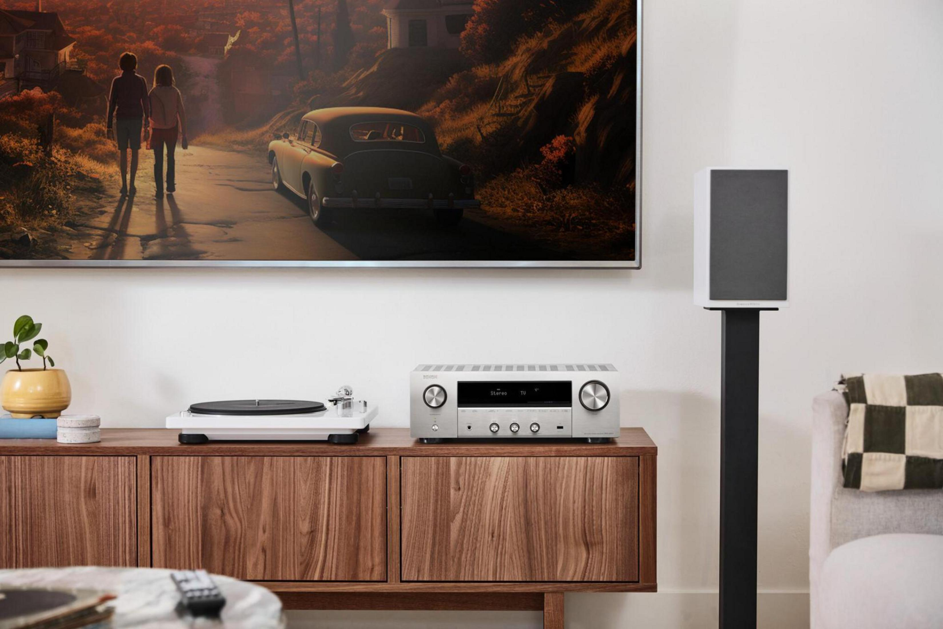 Scena del soggiorno: TV, stereo, giradischi, altoparlante e mobile in legno.