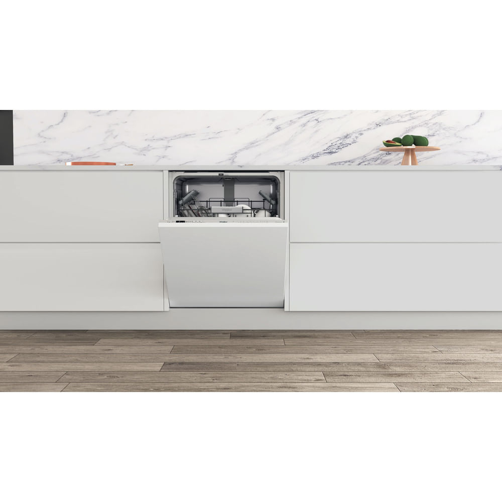 Built-in dishwasher with open door. White kitchen. Marble counter and wooden floor.