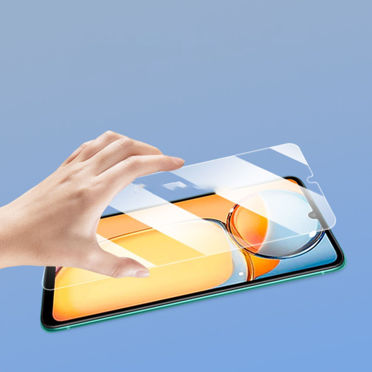 Una mano che tiene una protezione per lo schermo davanti a un telefono. Lo schermo del telefono mostra uno sfondo arancione.