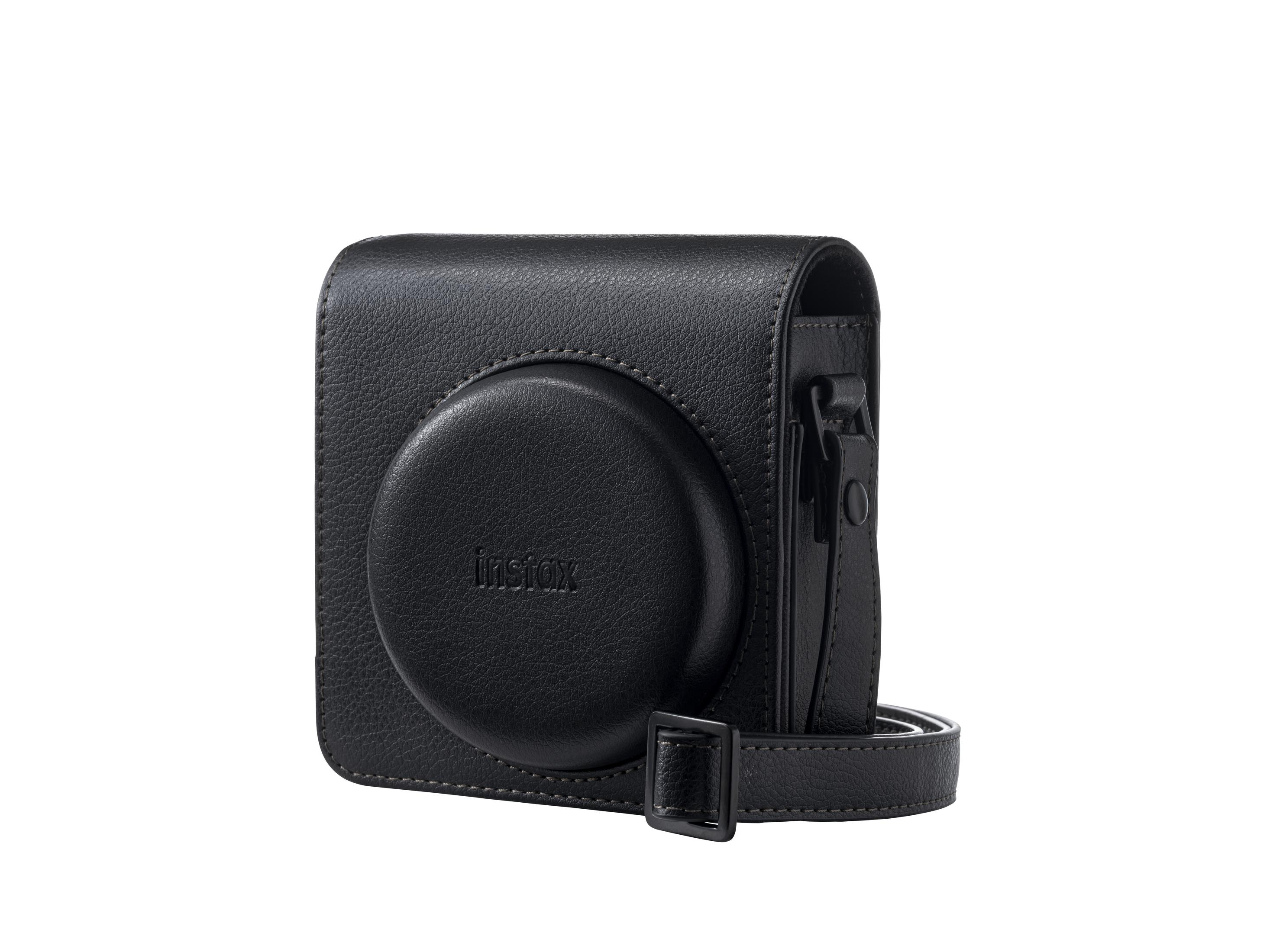 Eine schwarze Instax-Kameratasche mit Riemen. Die Tasche ist quadratisch mit runder Front. 'instax' ist gedruckt.