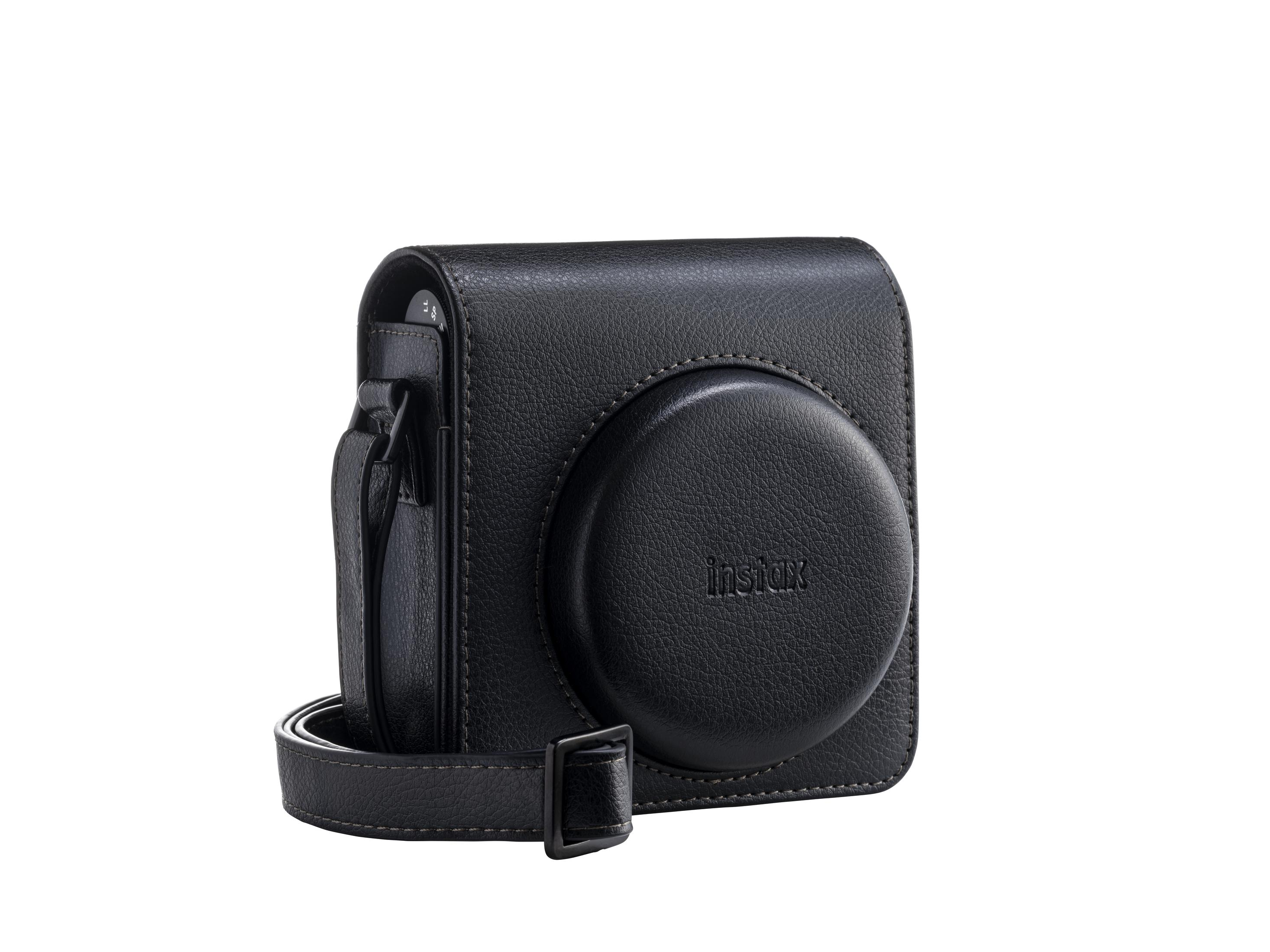 Schwarzes Instax-Kameratasche mit Riemen. Lederähnliches Material. Runde Front mit 'instax'-Text. Weißer Hintergrund.