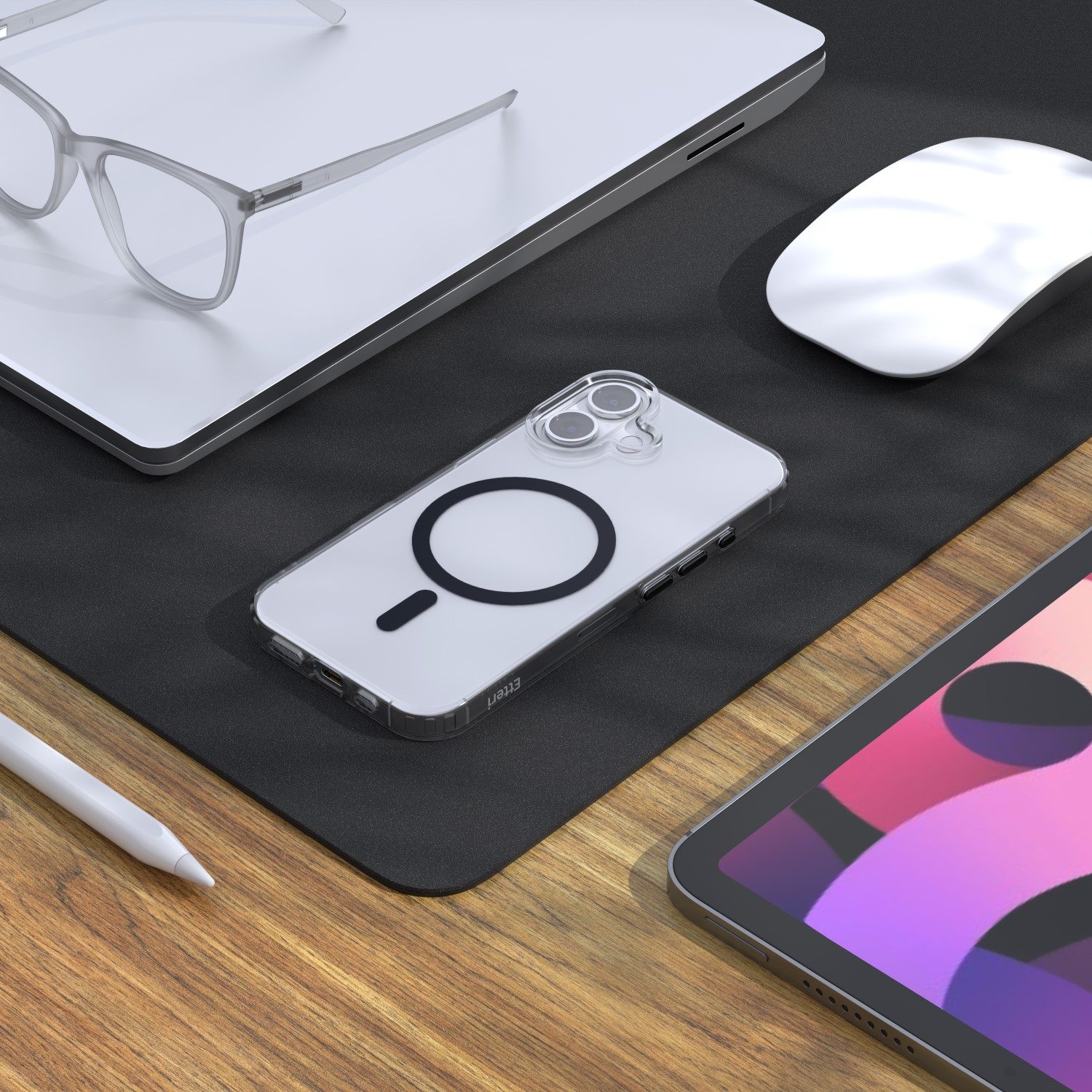 Un tavolo con un laptop, occhiali, telefono, mouse e un tablet. Una penna è accanto al tablet.