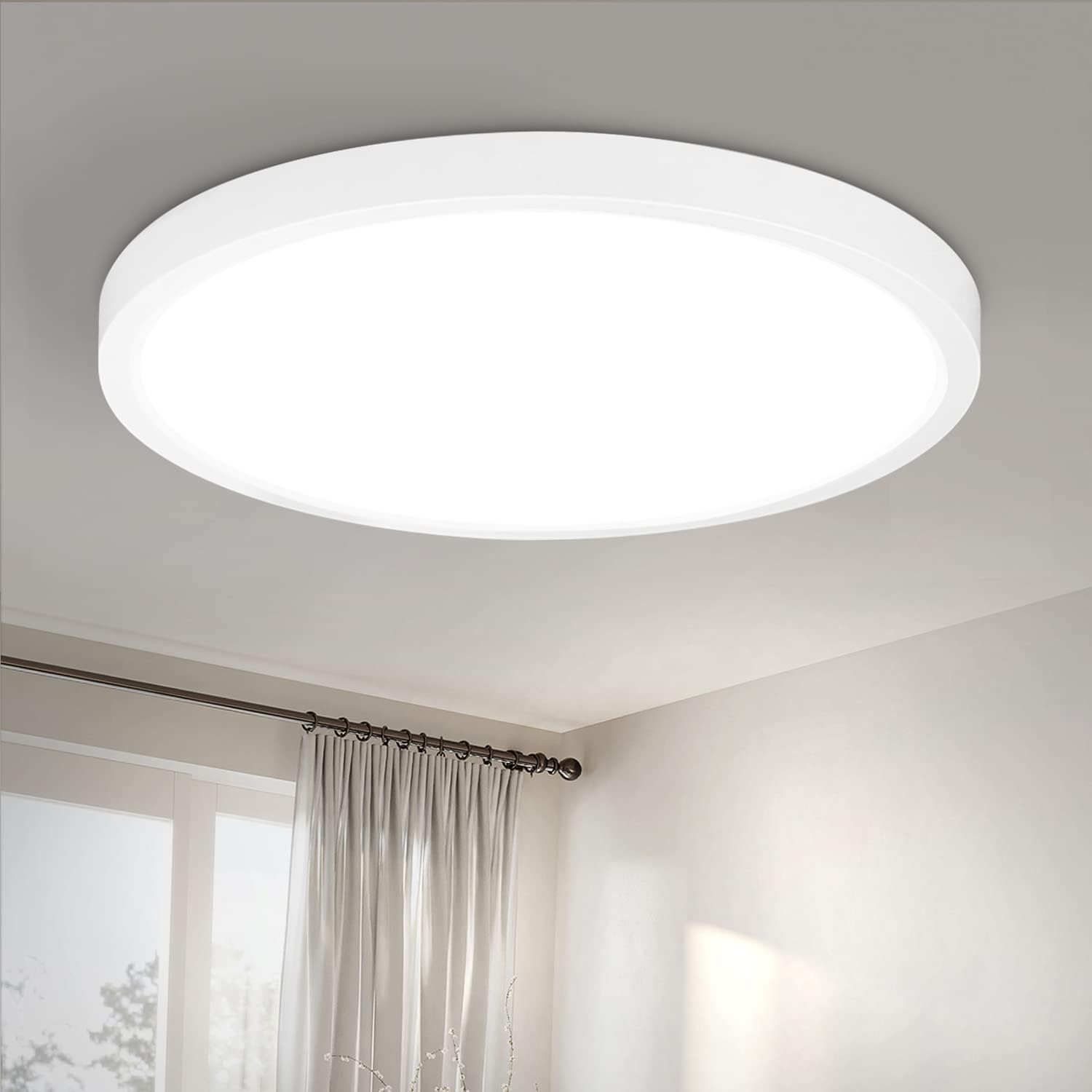 Luce da soffitto circolare bianca. La luce è accesa e brillante. È montata sul soffitto.