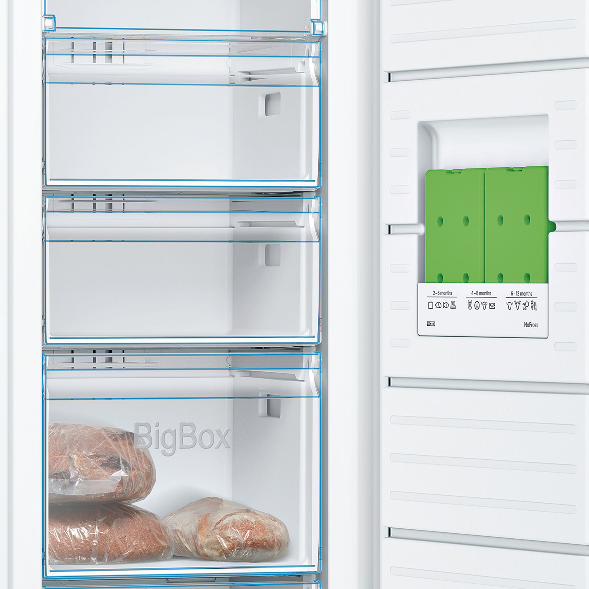 Offener Kühlschrank mit weißen Schubladen und grünen Kühlakkus. Einige Lebensmittel sind unten.