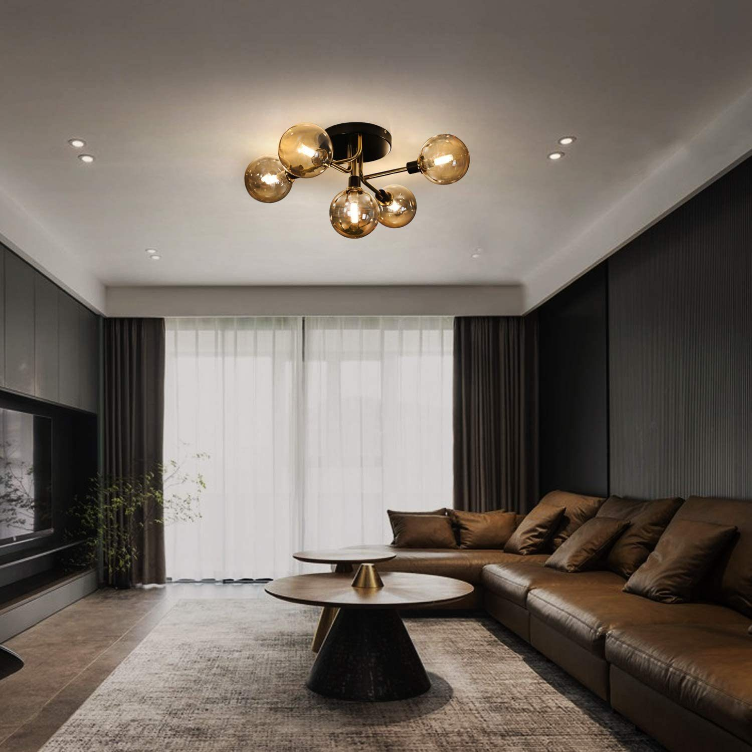 Ein Wohnzimmer mit Deckenleuchte. Das Zimmer hat eine Ledercouch, einen Teppich und einen Couchtisch.