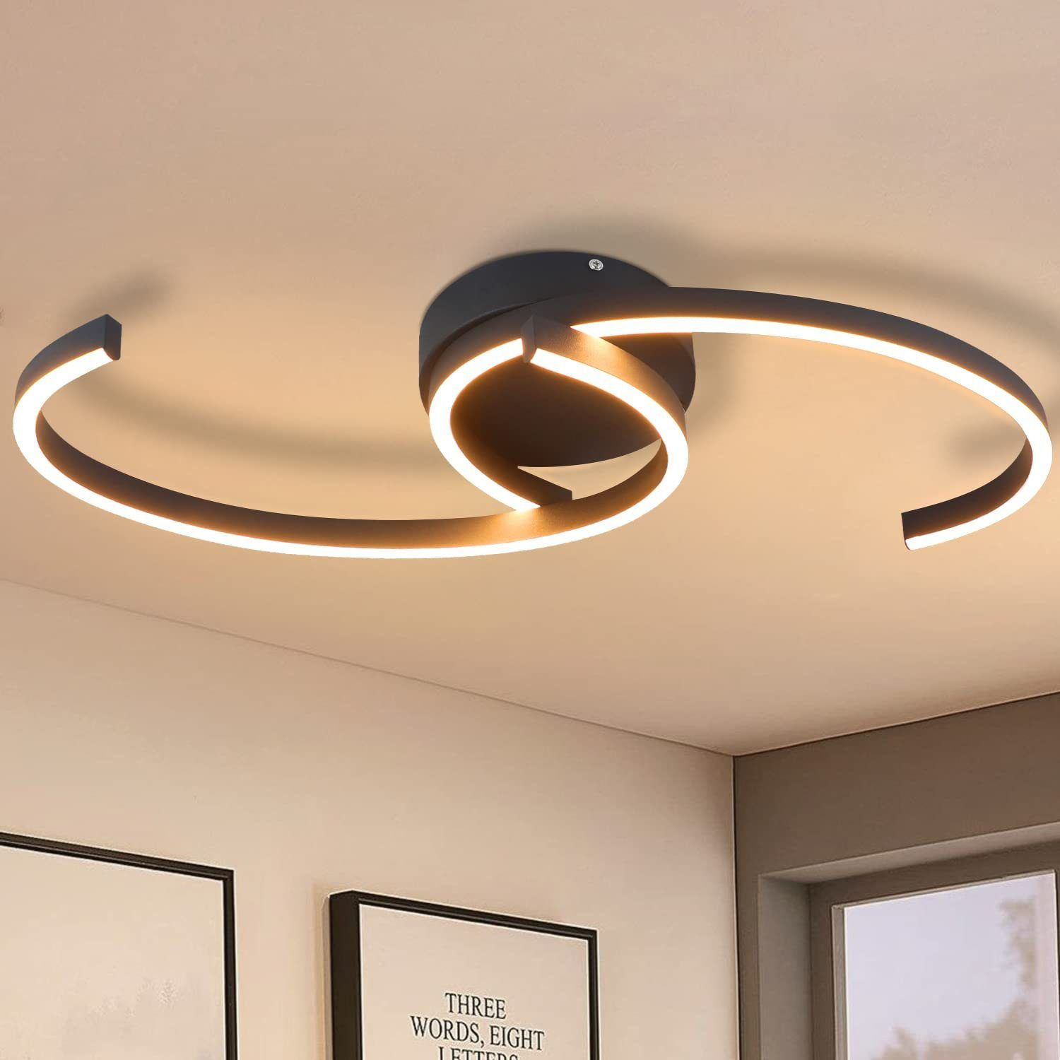 Czarna lampa sufitowa o zakrzywionym kształcie, emitująca światło. Na neutralnym tle.