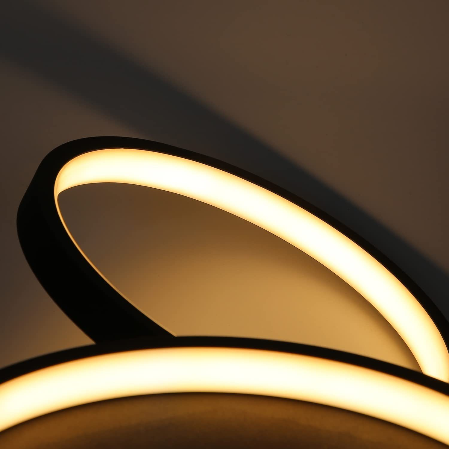 Nahaufnahme einer Deckenleuchte, die warmes Licht ausstrahlt, mit geschwungenem Design.