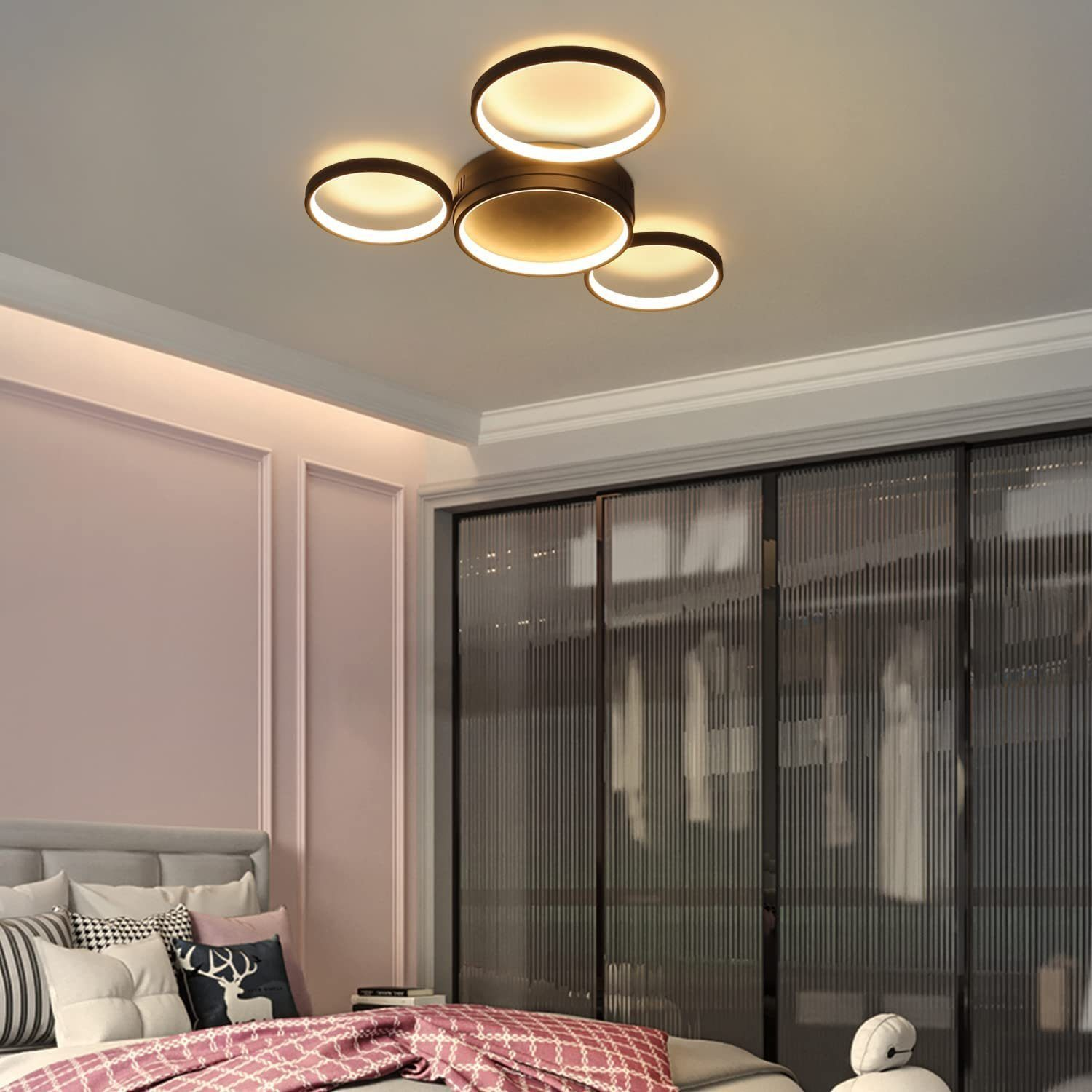 Vier runde Deckenleuchten in einem Schlafzimmer. Die Lichter sind bronze und weiß.