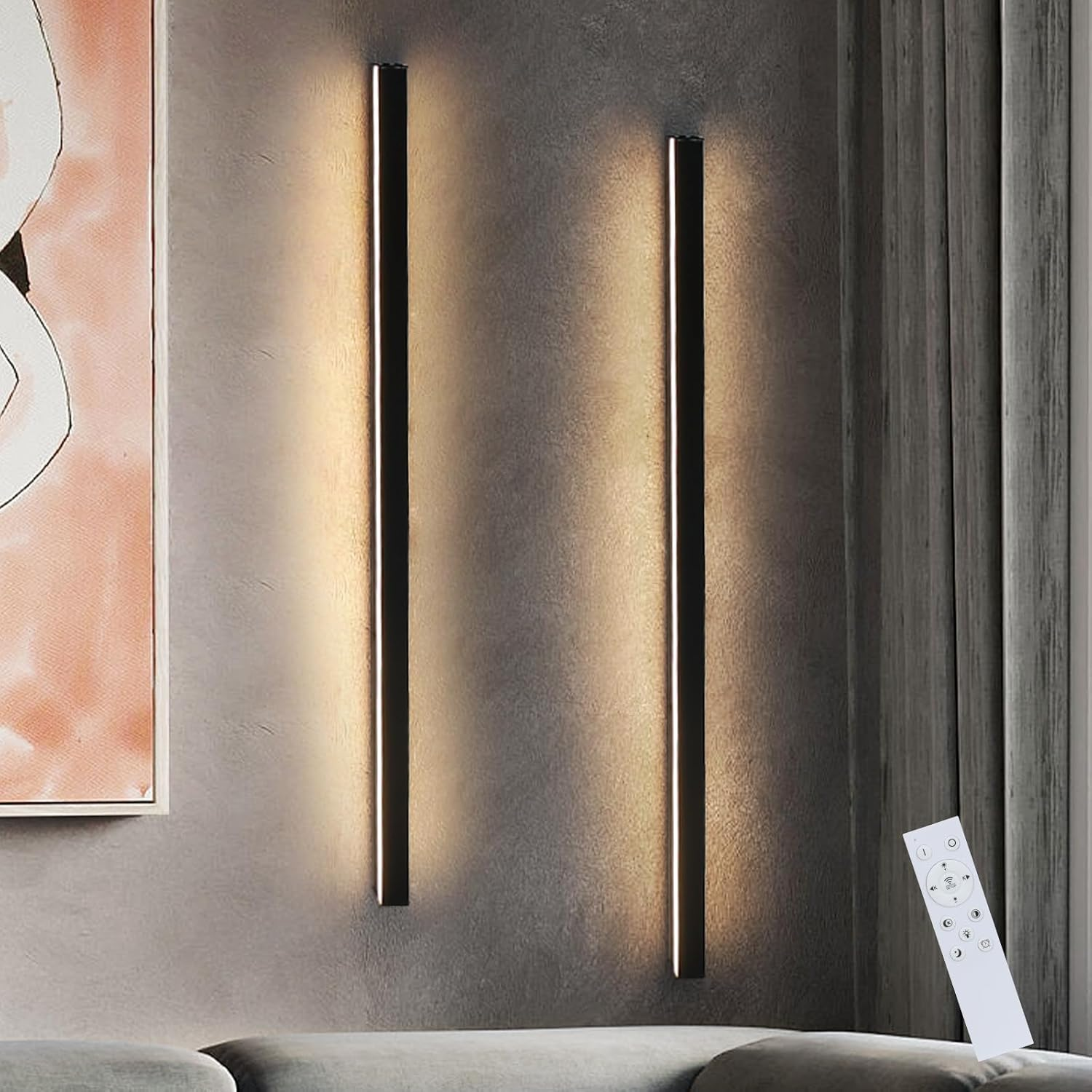 Due strisce luminose a parete con un telecomando. Il muro è grigio.