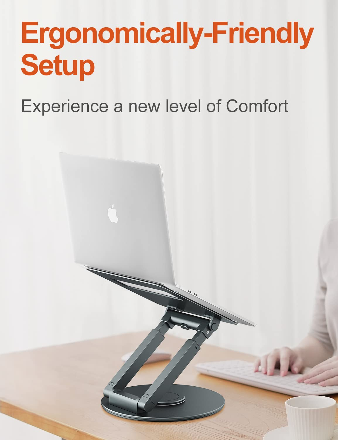 Ein Laptop auf einem Ständer. Der Laptop ist geöffnet und angewinkelt. Der Hintergrund zeigt eine Tastatur und einen Arm.