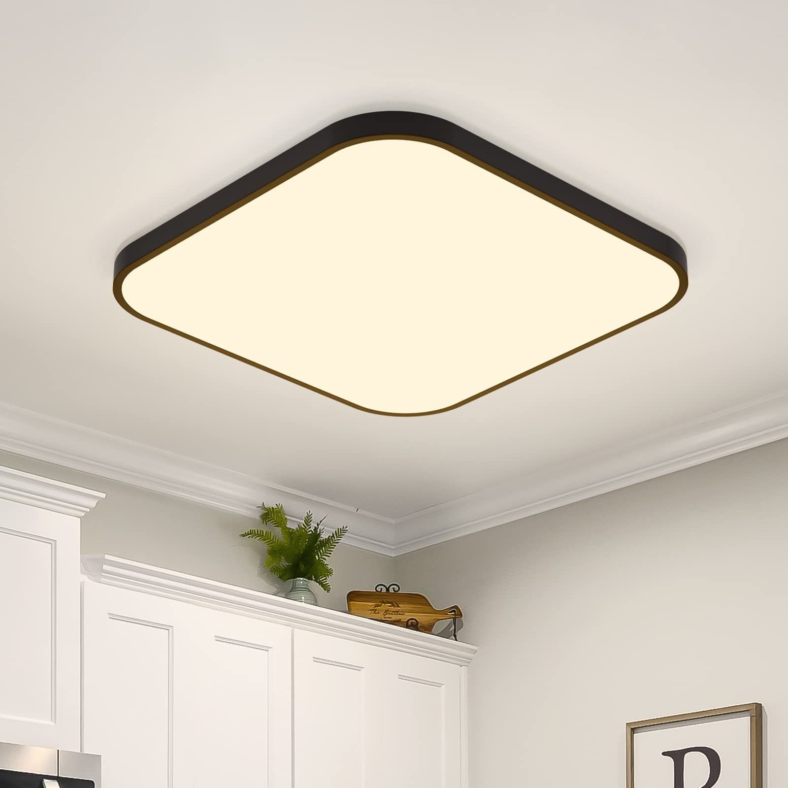 Quadratische LED-Deckenleuchte mit schwarzem Rahmen, an weißer Decke montiert.
