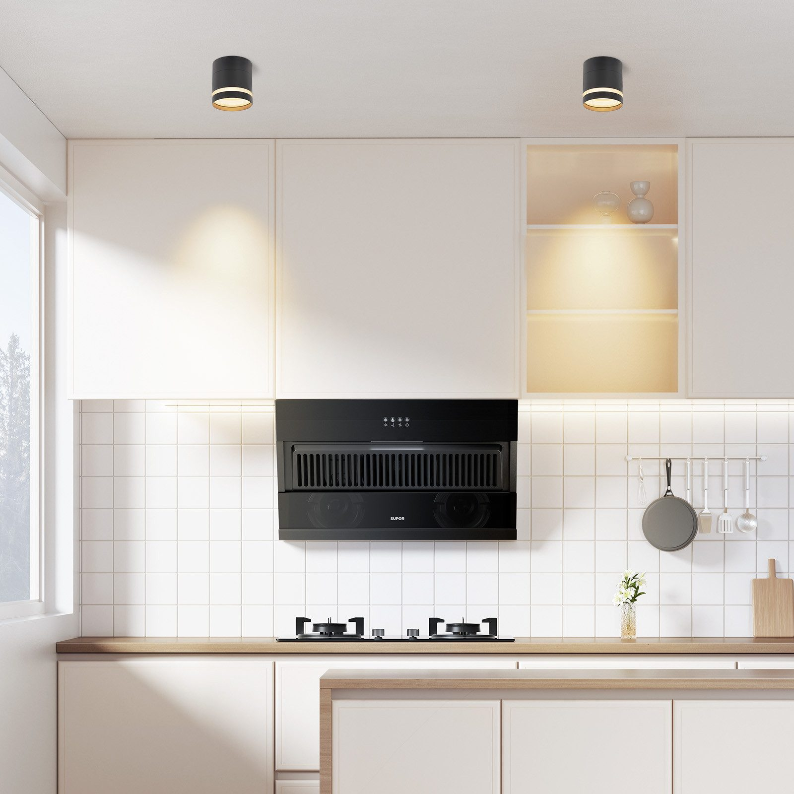 Cucina moderna con mobili bianchi, cappa nera e due luci a soffitto.
