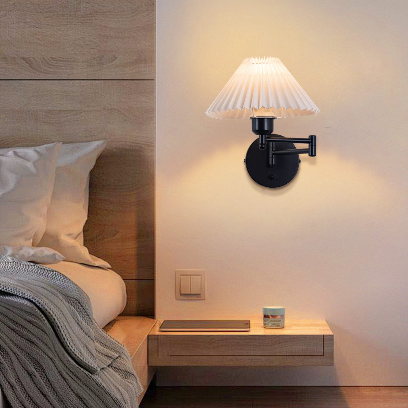 Una lampada da parete nera con paralume bianco montata su una parete color crema.