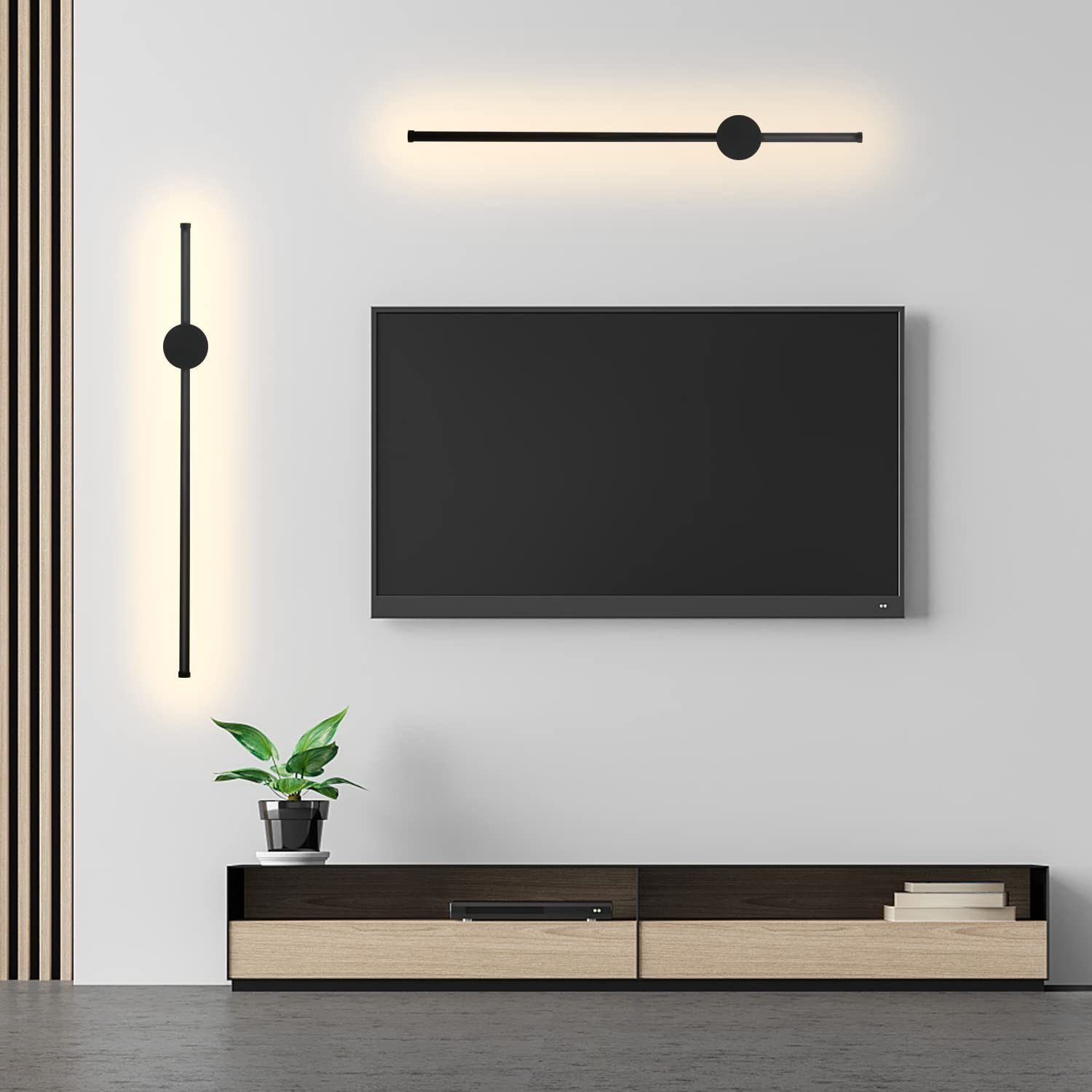 Un soggiorno con TV, luci e una pianta su un mobile. Le pareti sono bianche.