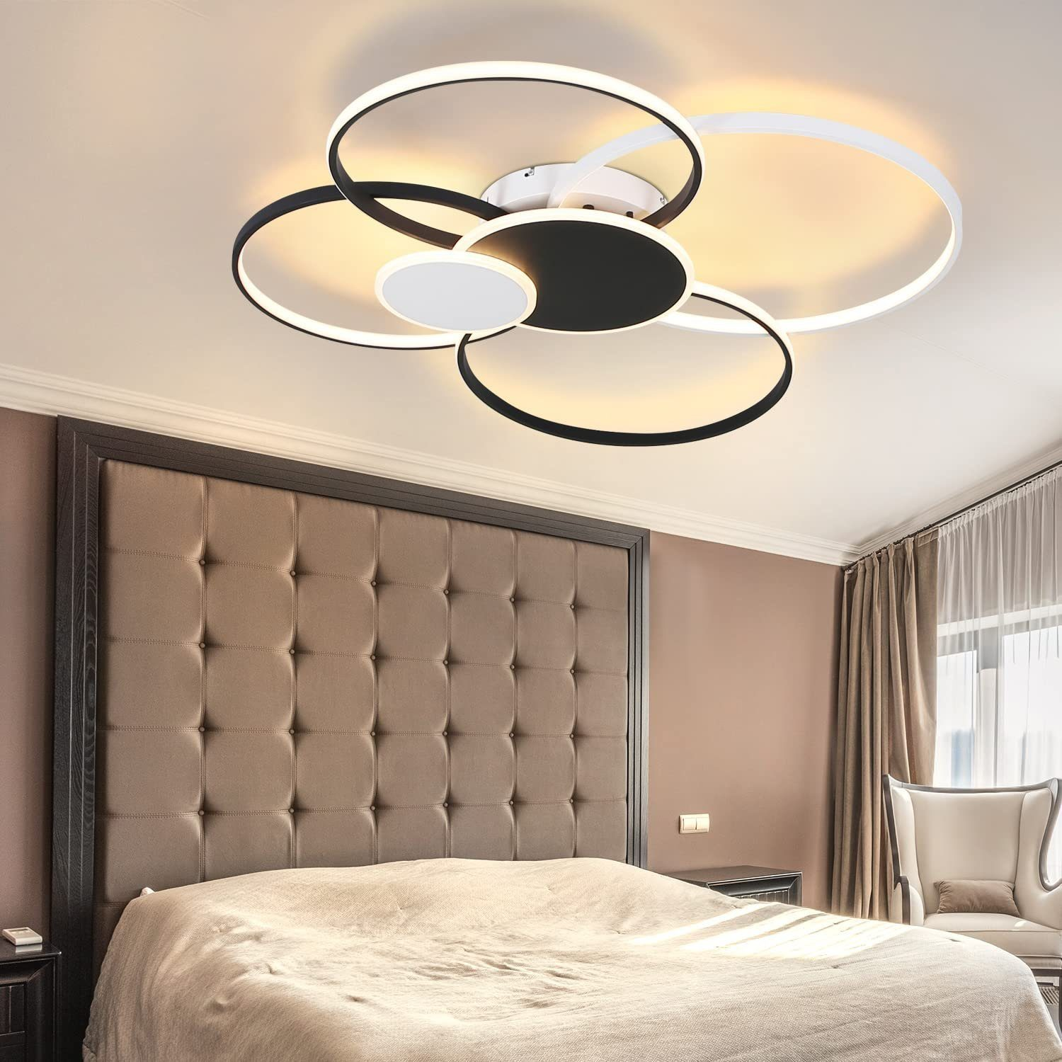 Eine moderne Deckenleuchte mit schwarzen und weißen Kreisen. Das Licht ist in einem Schlafzimmer installiert.