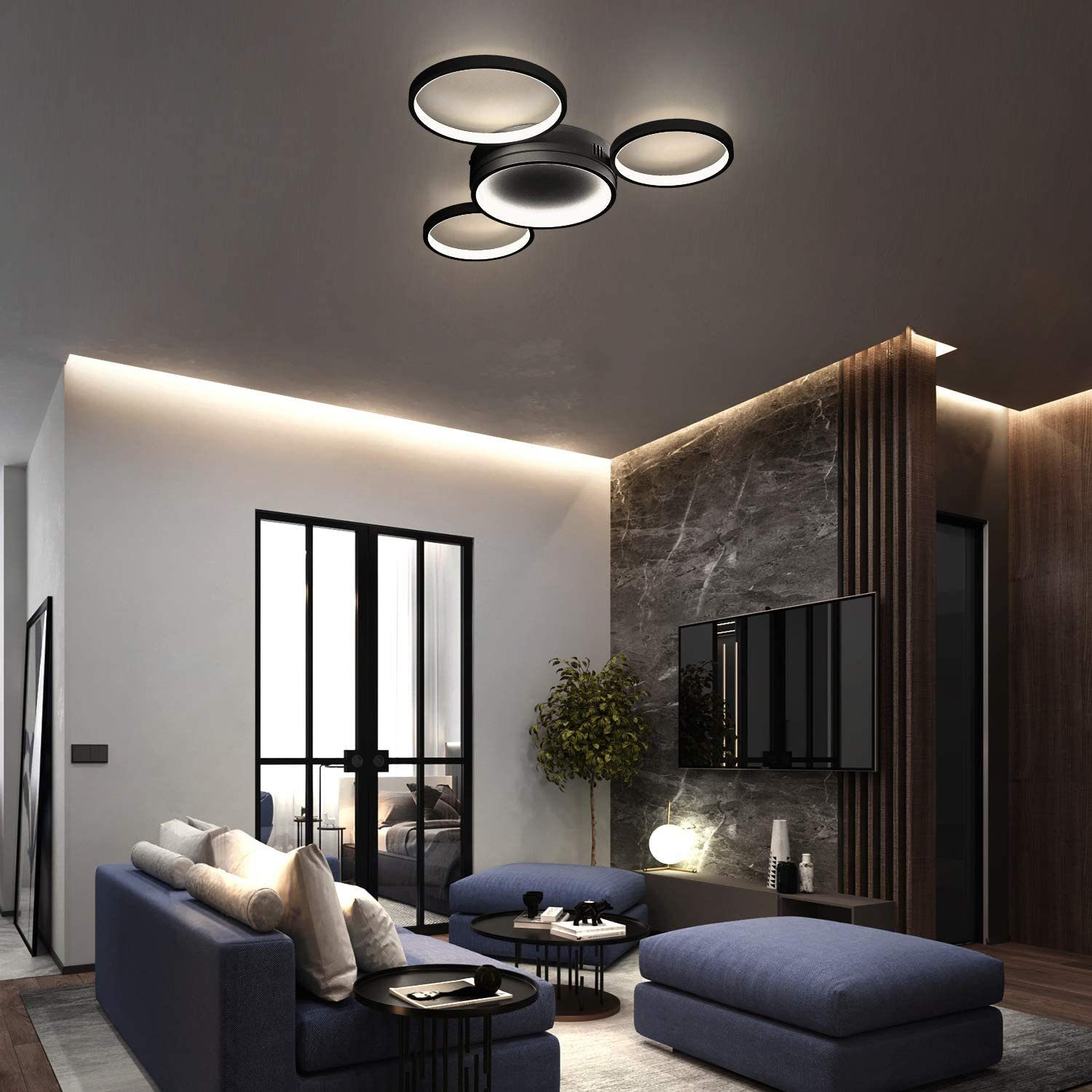 Modernes Wohnzimmer mit blauem Sofa, schwarzen Tischen, Deckenleuchten und einem großen Fernseher an einer Marmorwand.
