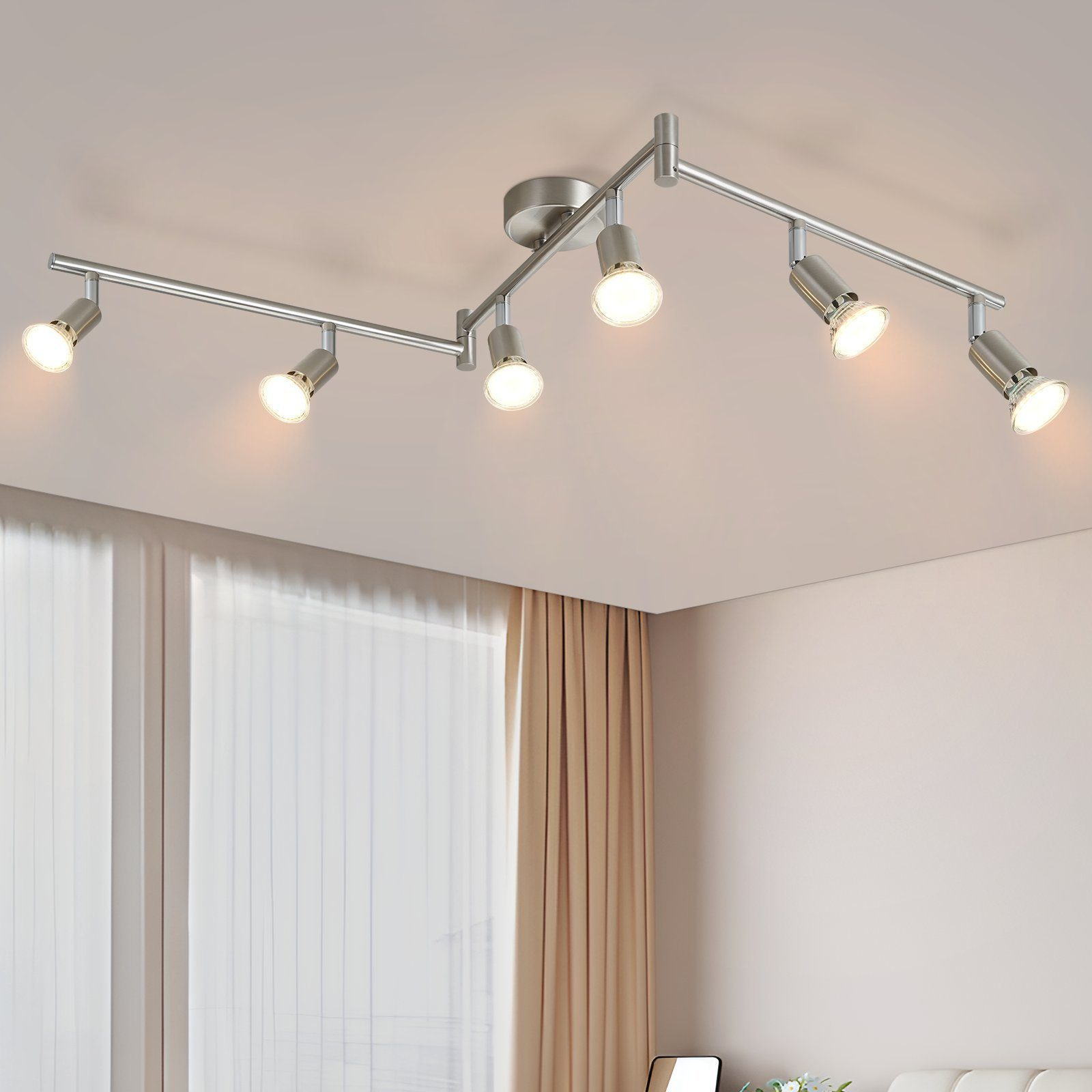 Techo con seis focos, dispuestos sobre una pista curva. Las luces están encendidas, iluminando la habitación.