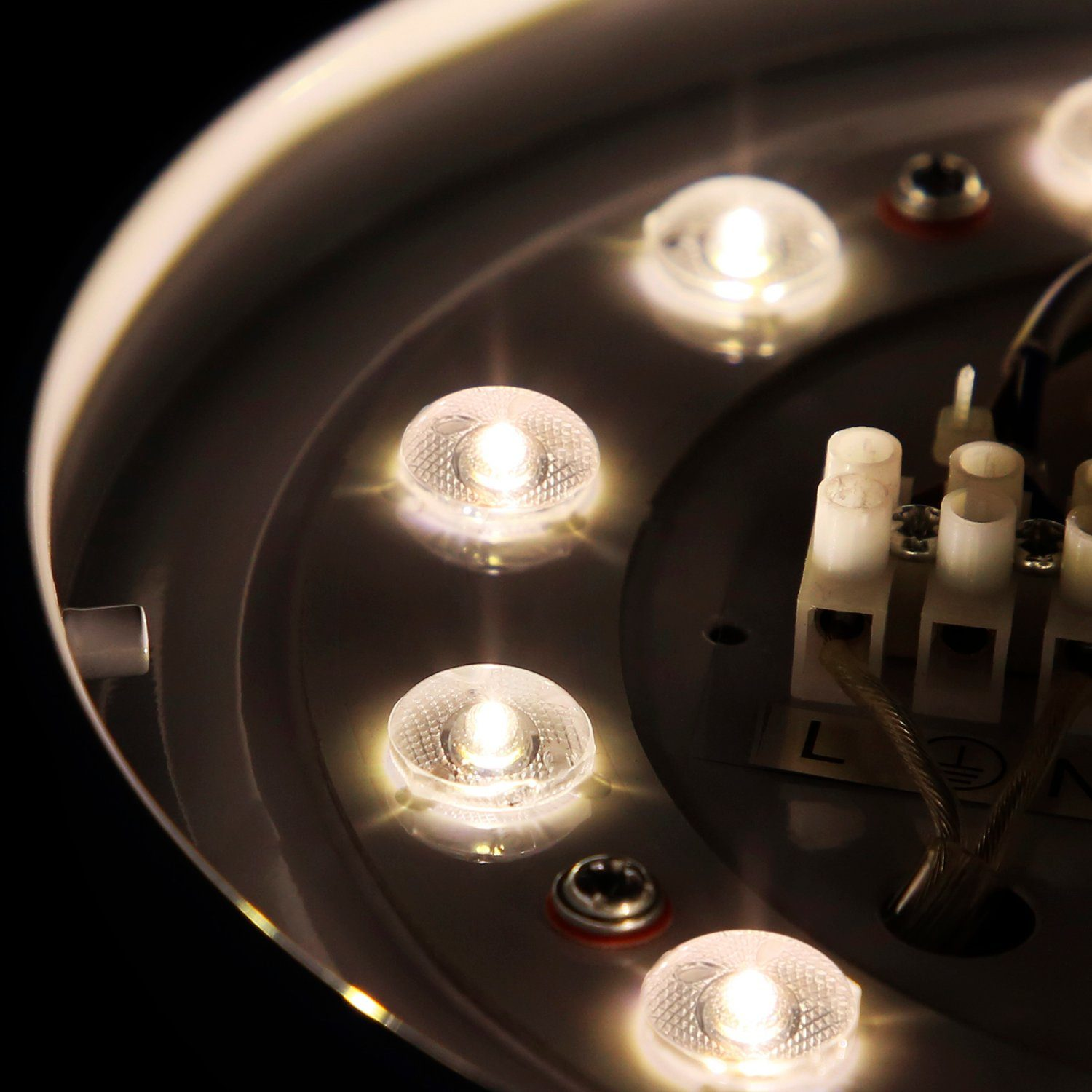Nahaufnahme einer runden LED-Leuchte mit mehreren kleinen, klaren Lichtern, weißes Gehäuse.