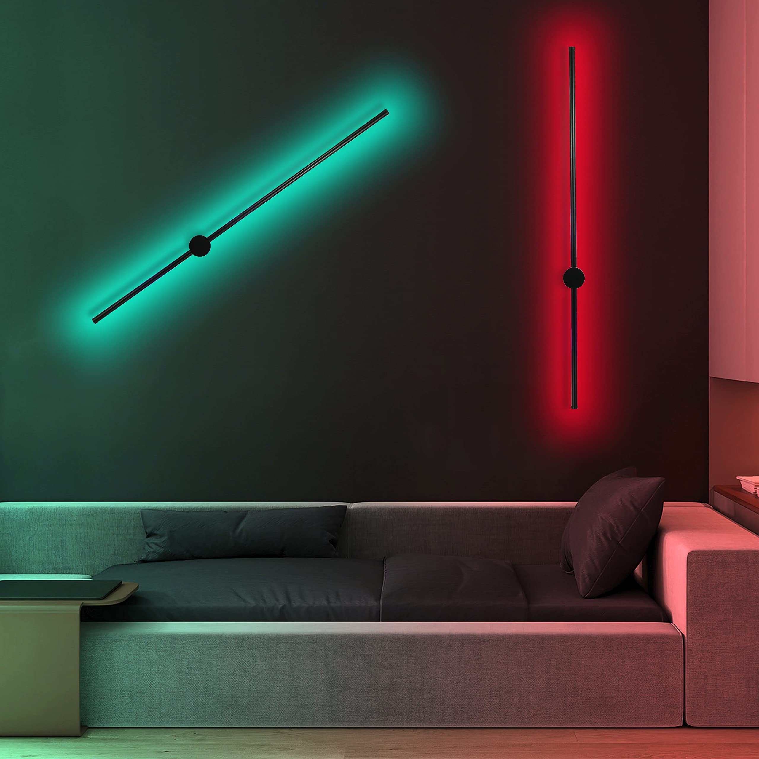 Dwie lampy ścienne emitujące zielone i czerwone światło. Szara sofa jest na pierwszym planie.
