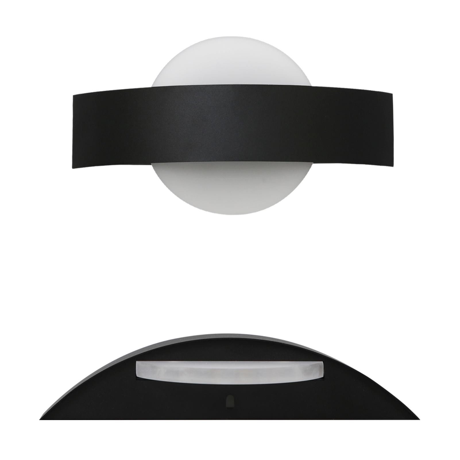 Lampa ścienna, czarno-biała. Okrągły i zakrzywiony design. Białe tło.