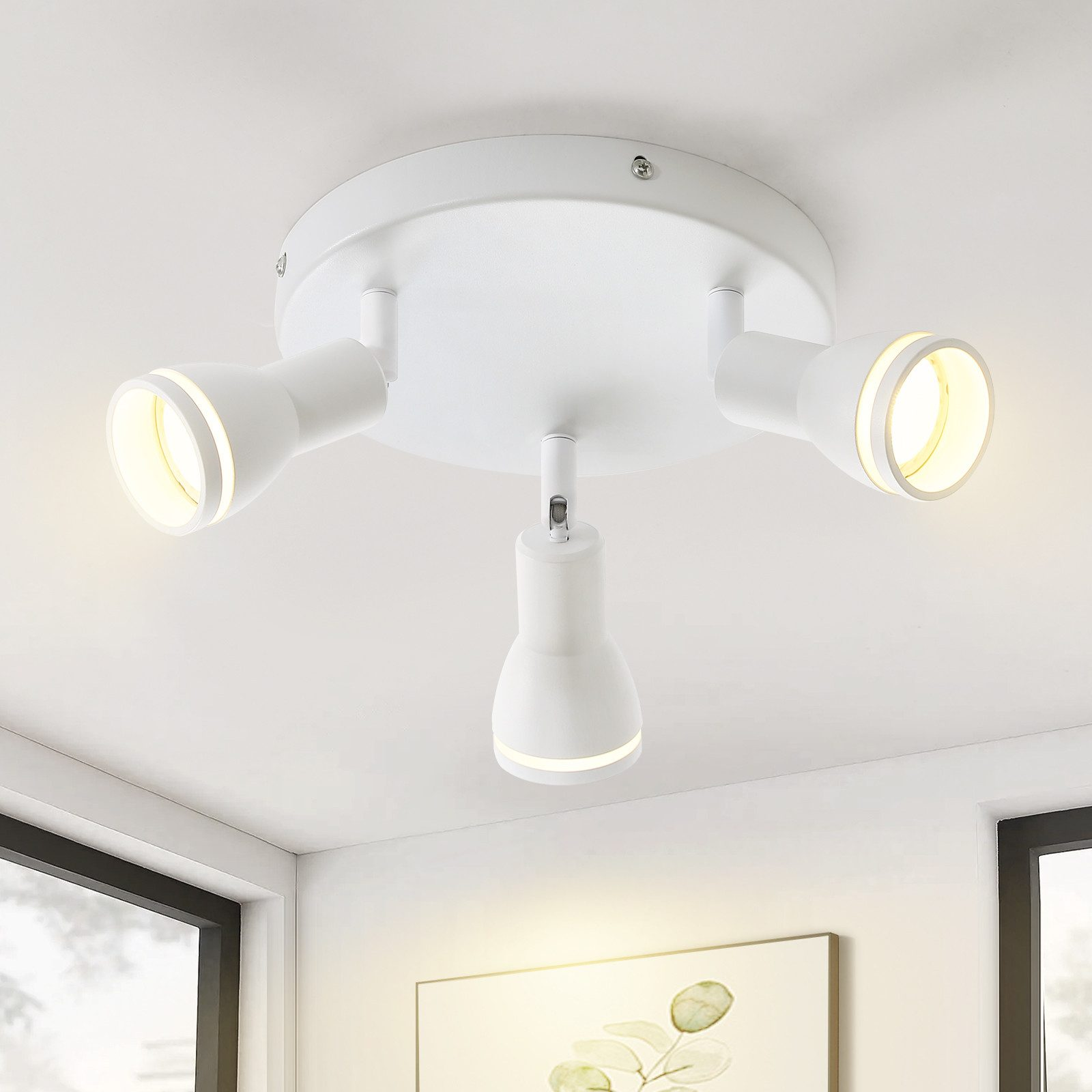 Faretti da soffitto bianchi. Tre teste regolabili, ognuna con luce. Montaggio a soffitto bianco.