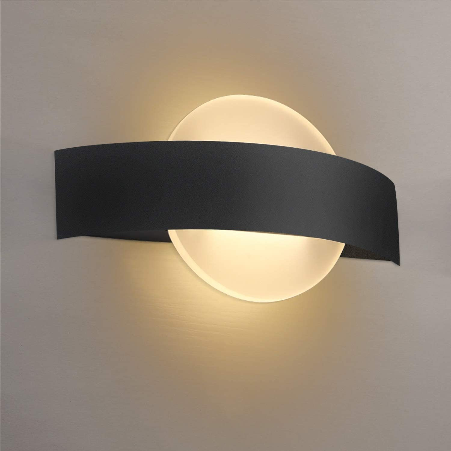 Nowoczesna czarna lampa ścienna, o zakrzywionym kształcie i jasnym świetle.