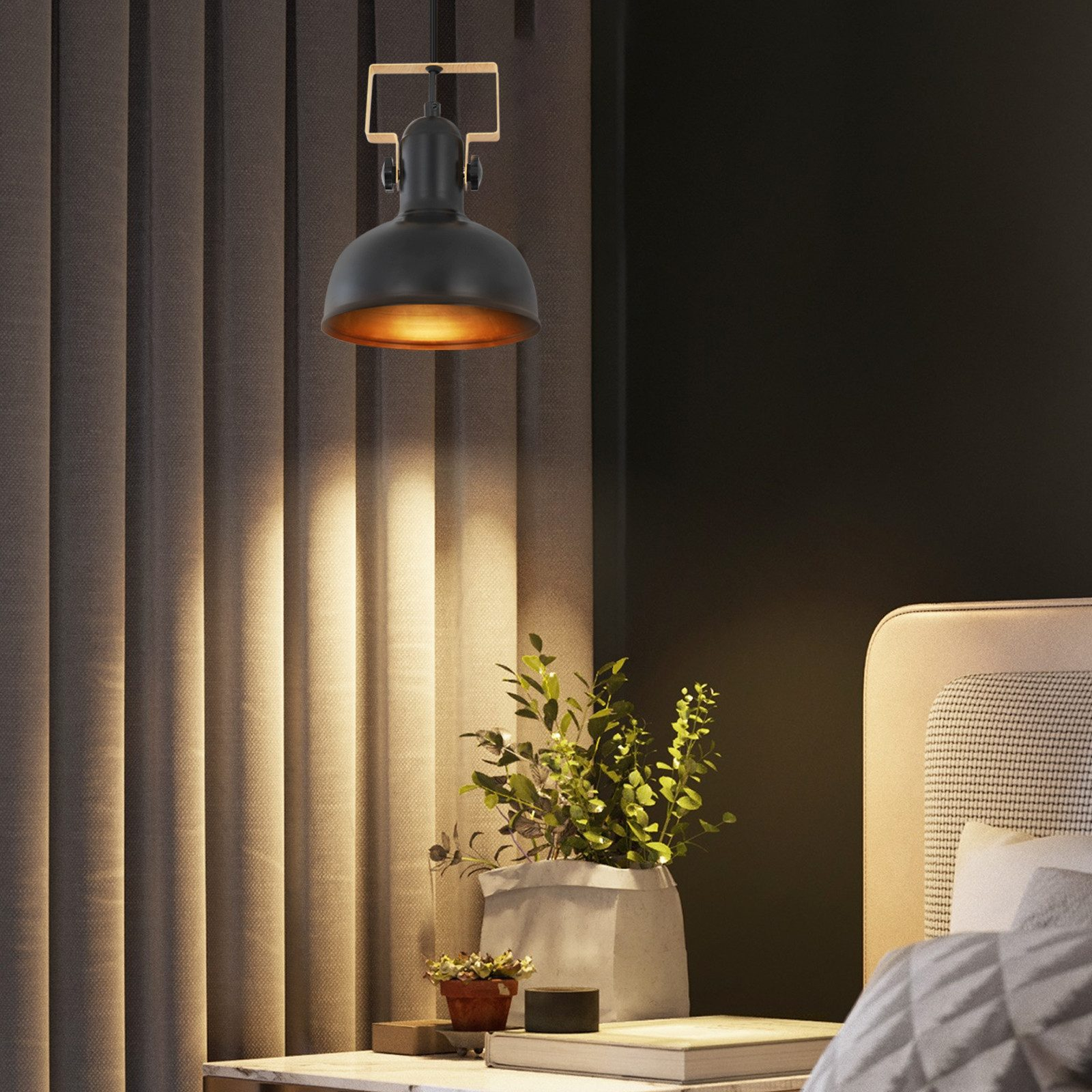 Schwarze Pendelleuchte mit goldenem Innenraum und einer kleinen Pflanze. Vorhänge und ein Bett im Hintergrund.