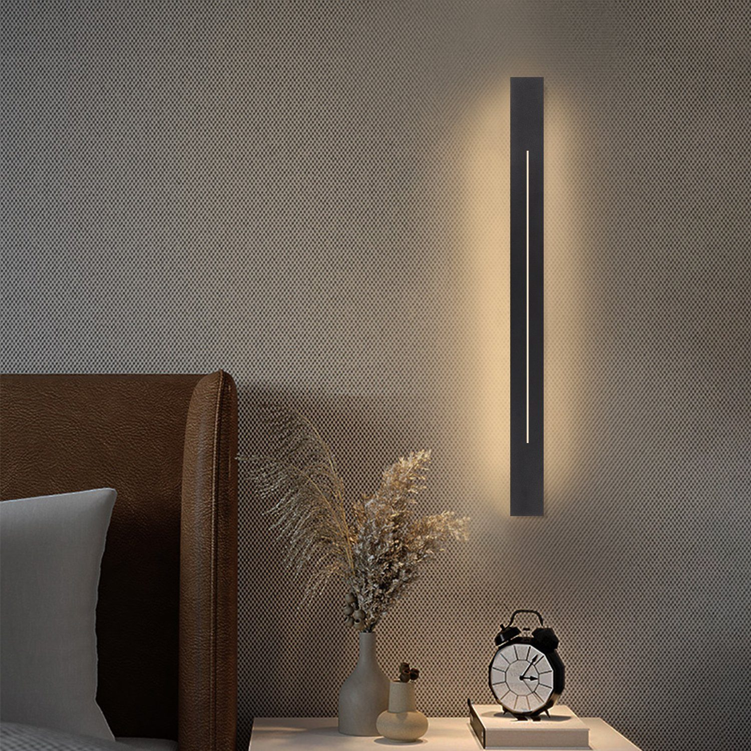 Una lampada da parete verticale con cornice nera e una singola striscia luminosa.