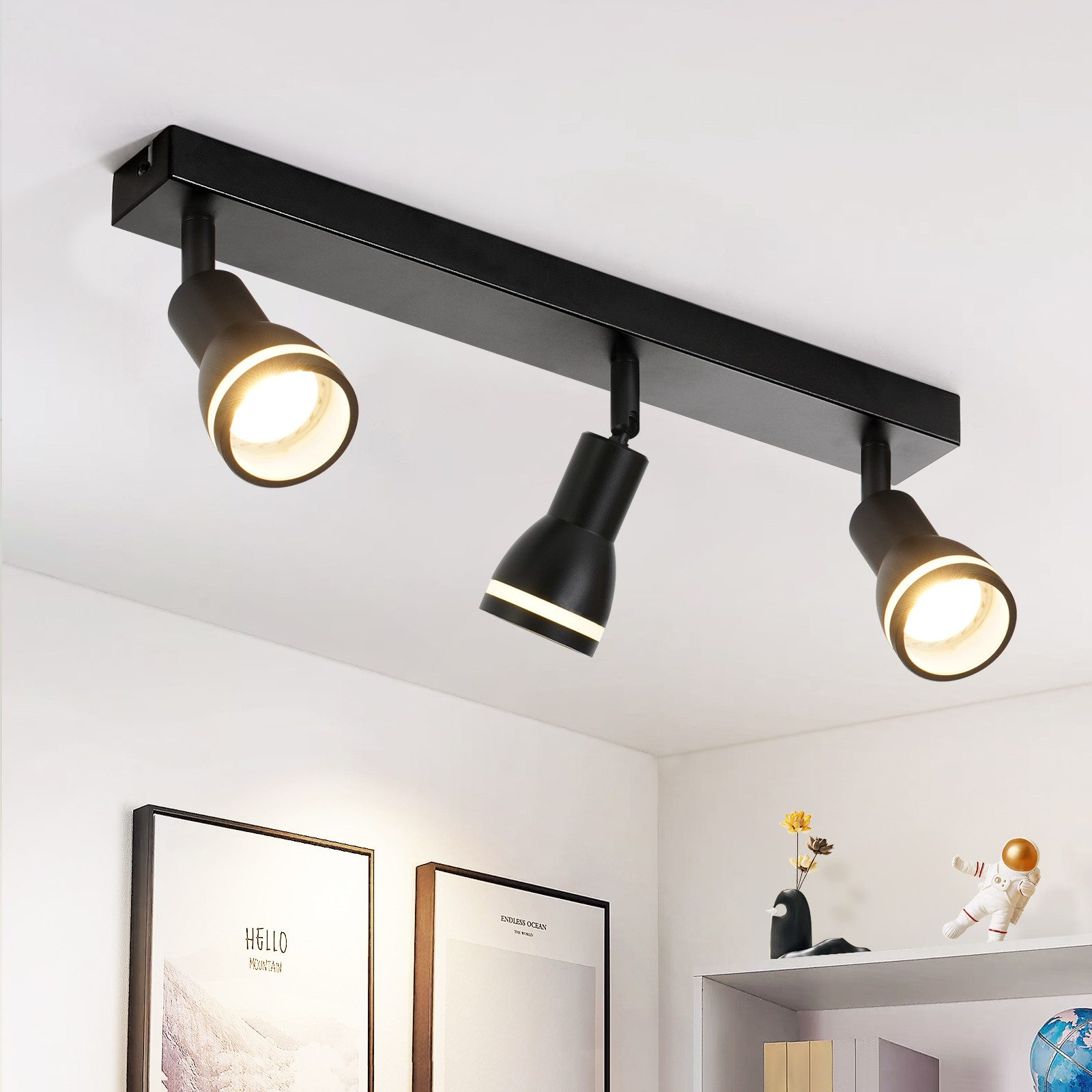Faretto da soffitto nero con tre luci che puntano in direzioni diverse.