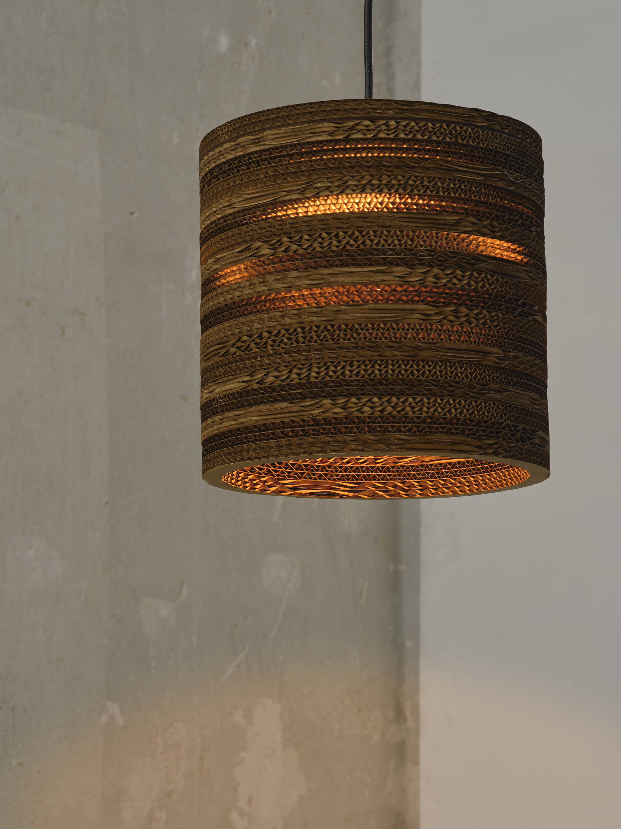 Hängende zylindrische Lampe aus geschichtetem Wellpappe.