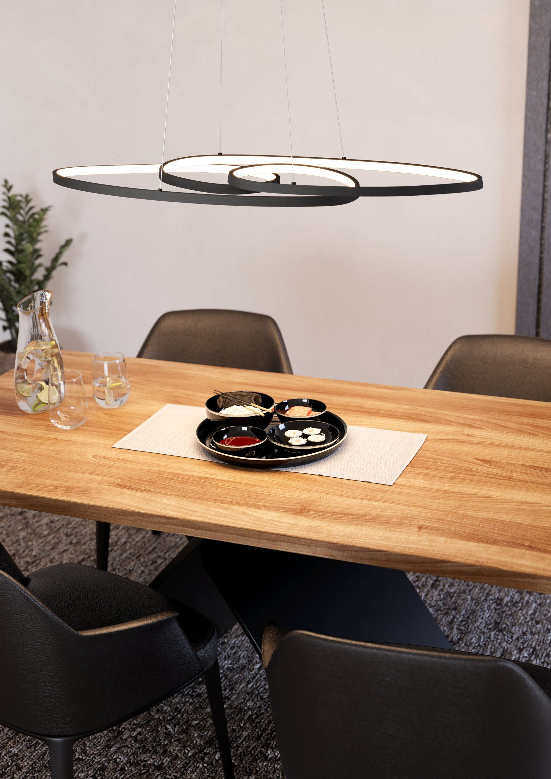 Esszimmer mit Holztisch, schwarzen Stühlen und moderner schwarzer Leuchte.