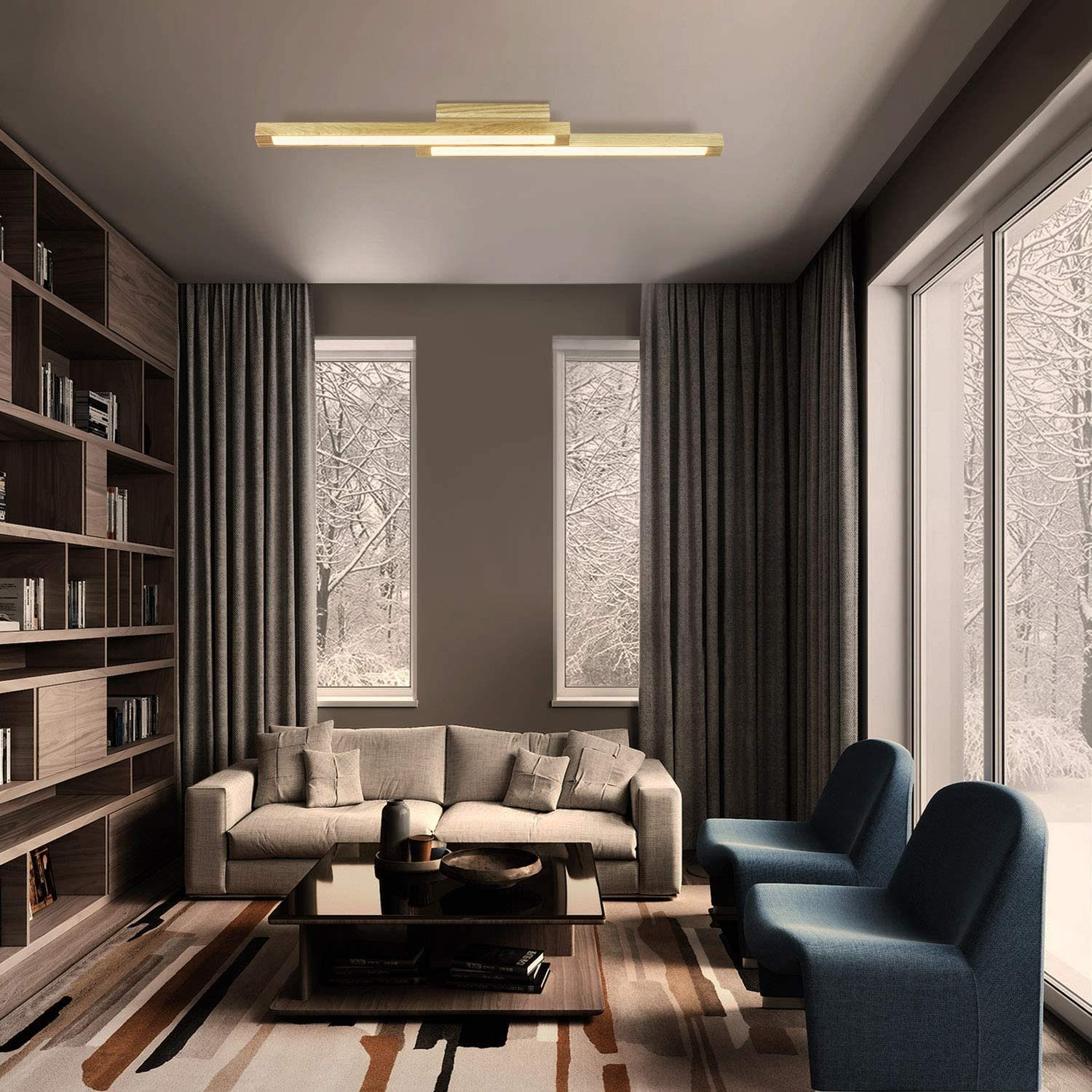 Ein Wohnzimmer mit Sofa, zwei Sesseln und Fenstern mit Blick auf eine verschneite Landschaft.