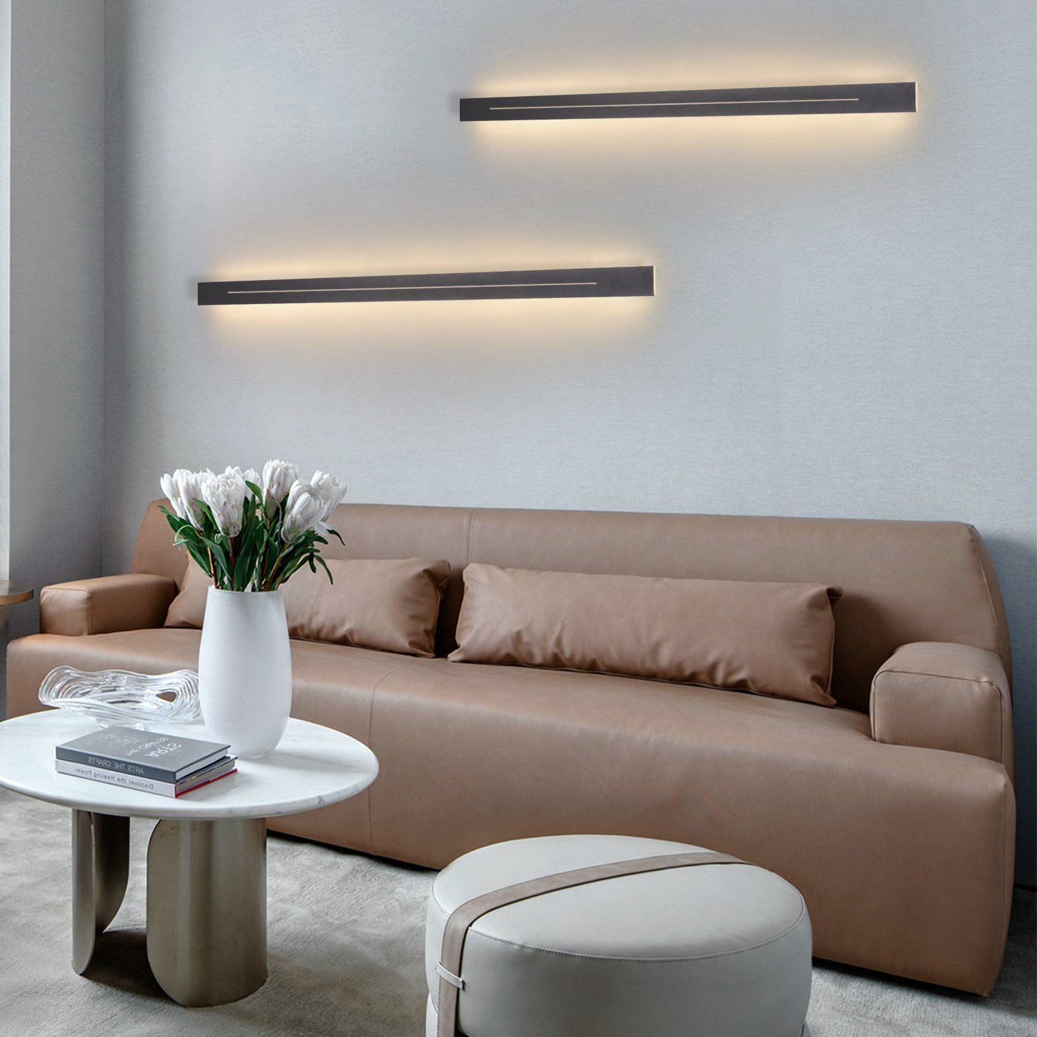 Dwie czarne lampy ścienne na szarej ścianie. W scenie znajduje się sofa, stół i kwiaty.