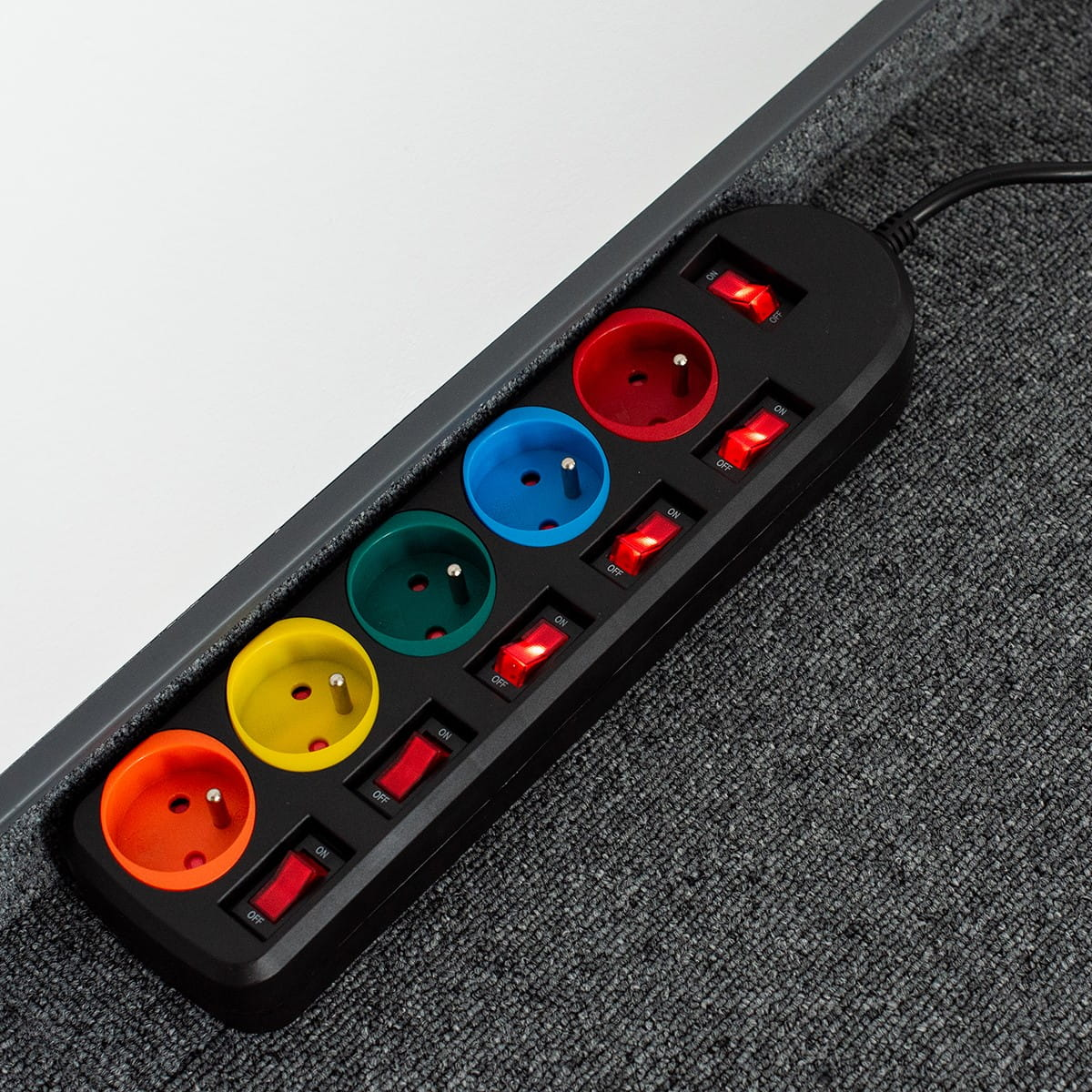 Listwa zasilająca z wieloma gniazdami w różnych kolorach.